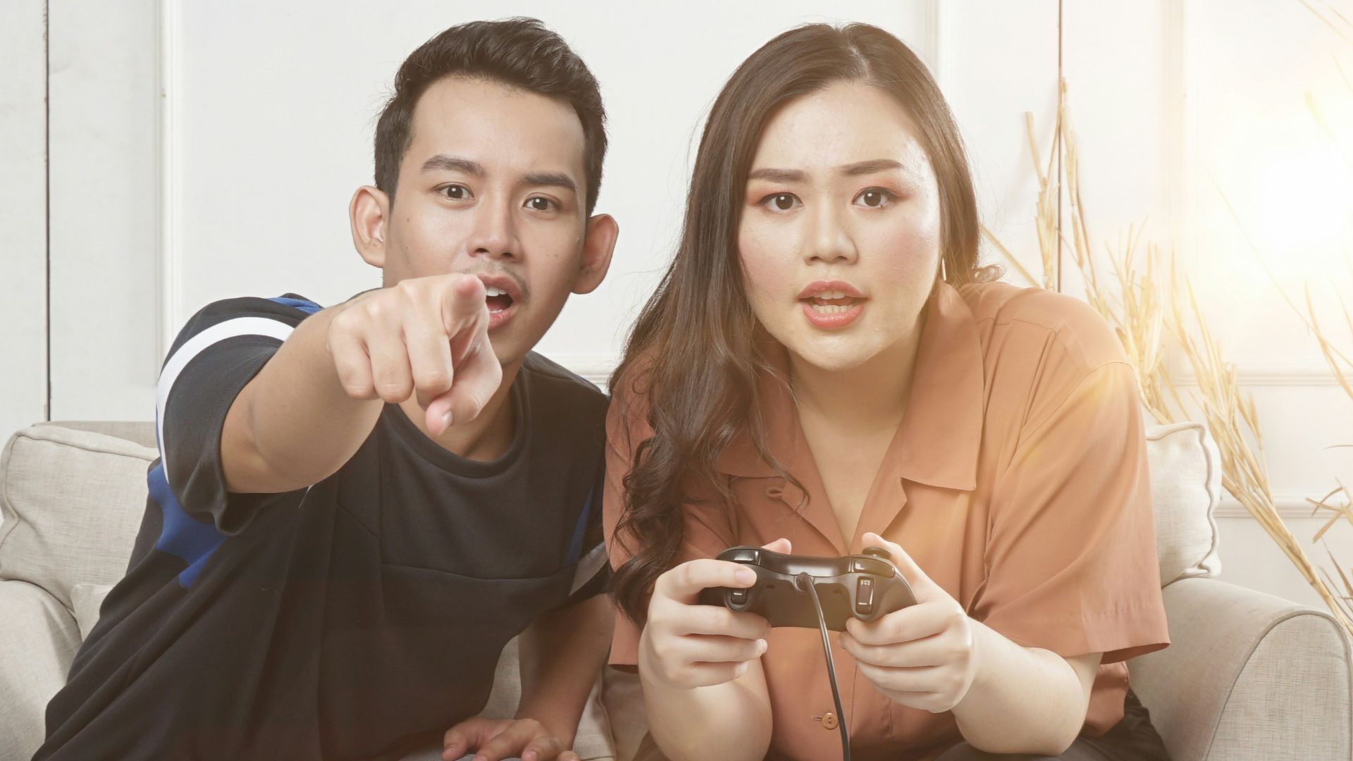 man and woman sitting on gray fabric loveseat
