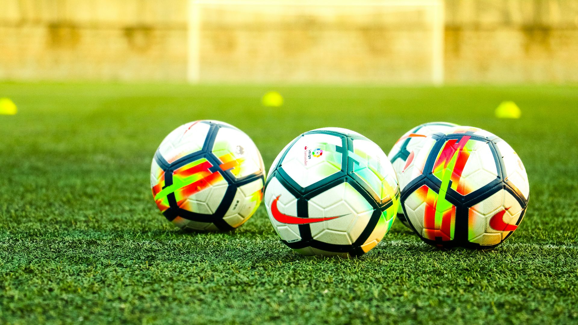 three white-and-black soccer balls on field