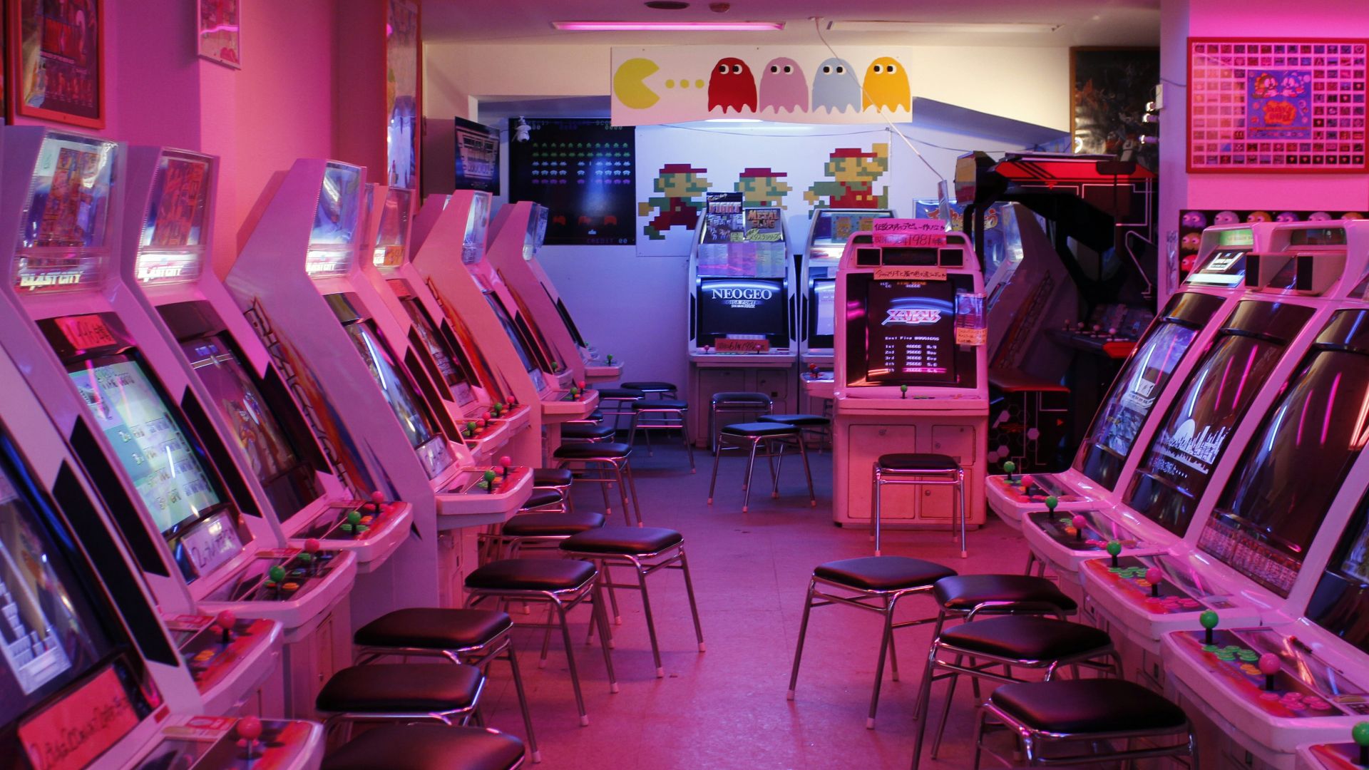turned-on arcade machines with stools