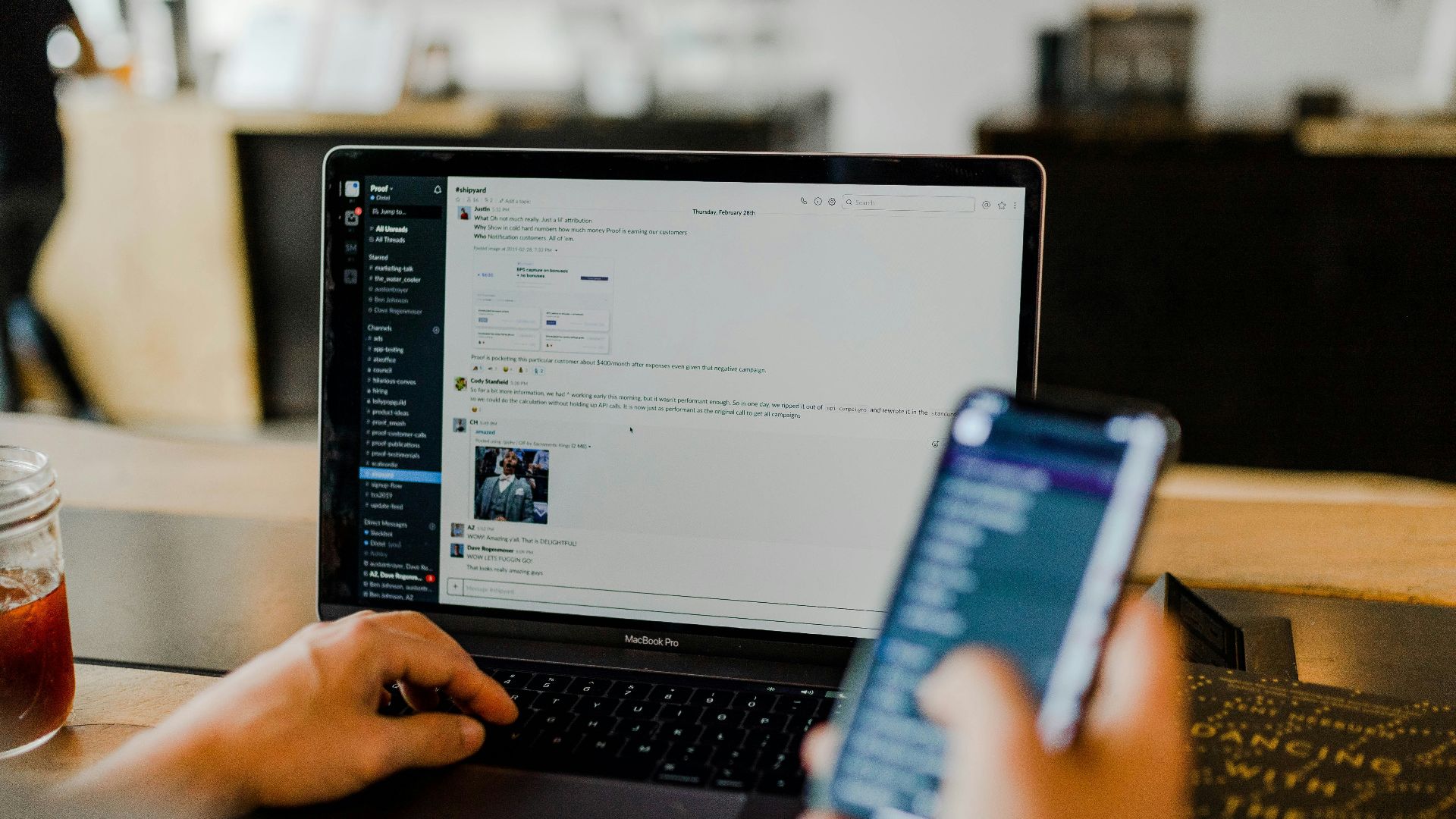 person using phone and laptop