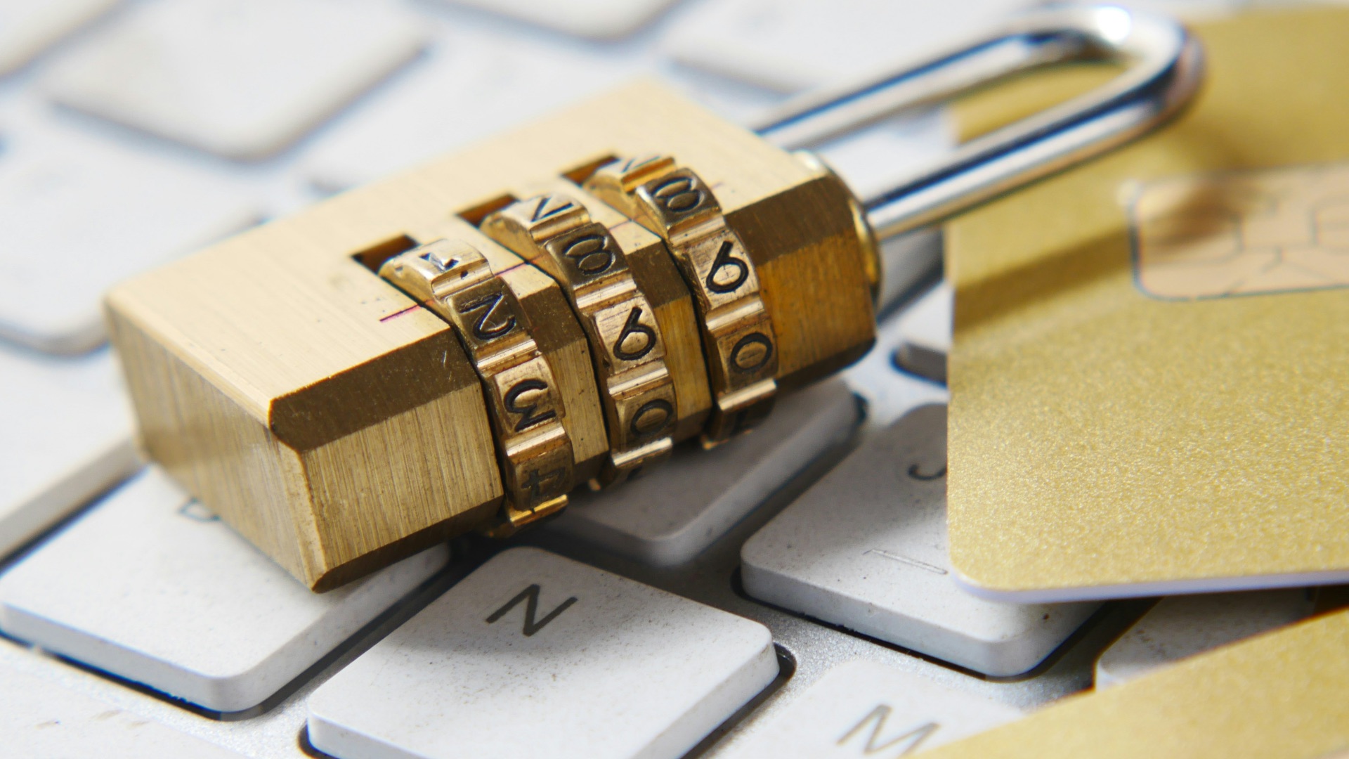 a golden padlock sitting on top of a keyboard