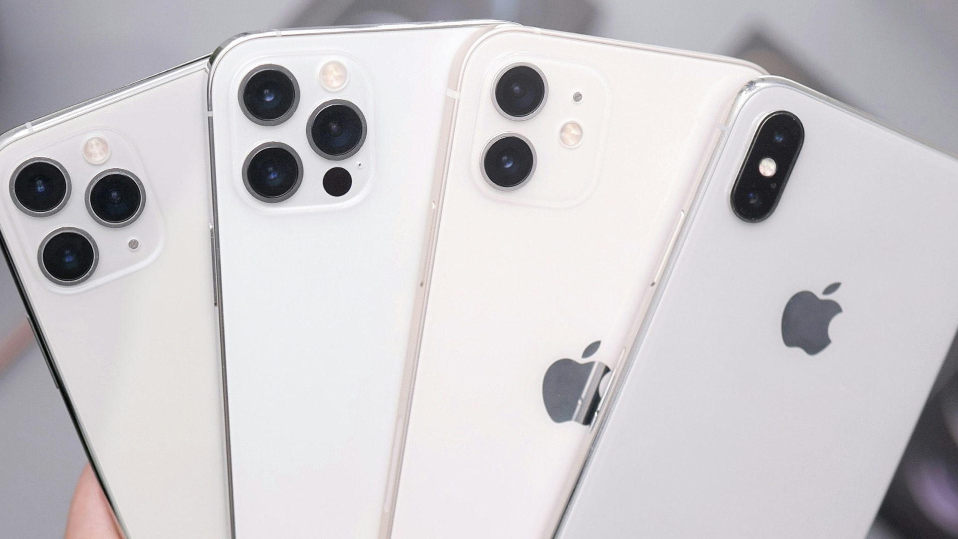 a person holding four iphones in their hands