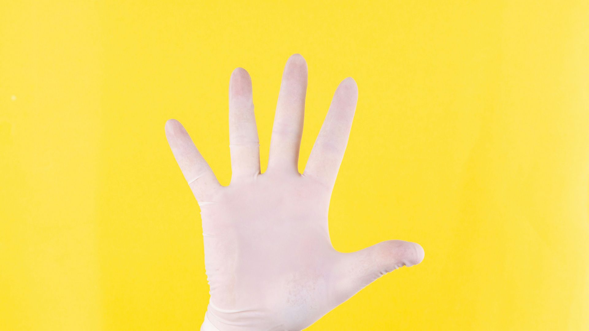 persons left hand on yellow background