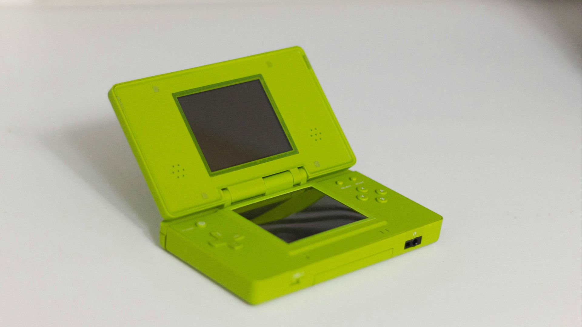 A lime green nintendo ds is displayed open.