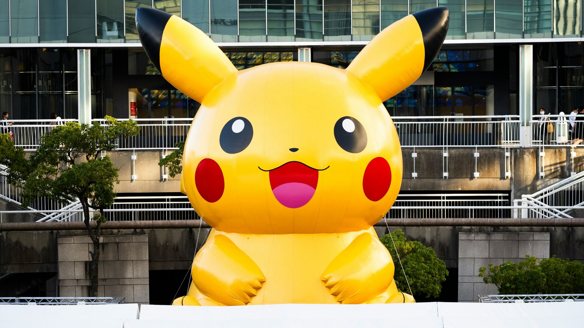 A group of people standing in front of a giant pikachu