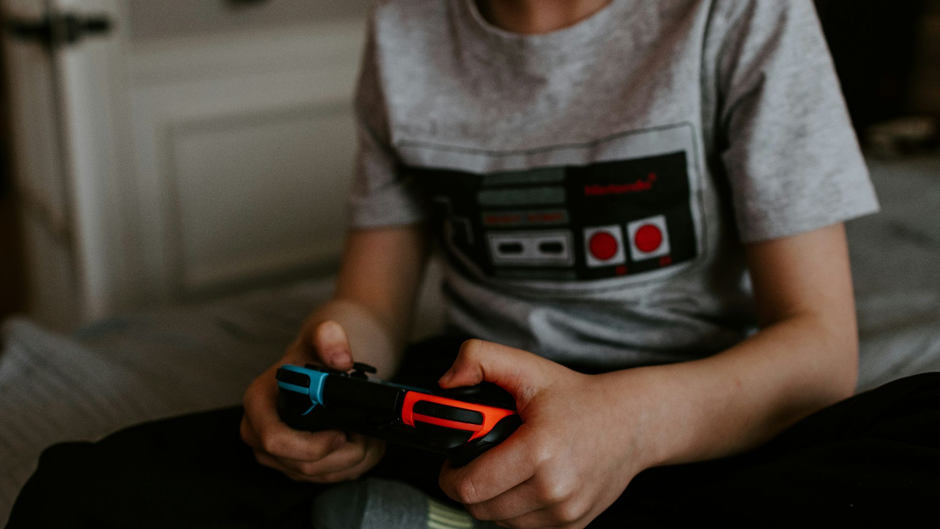 kid sitting on gray bed while playing