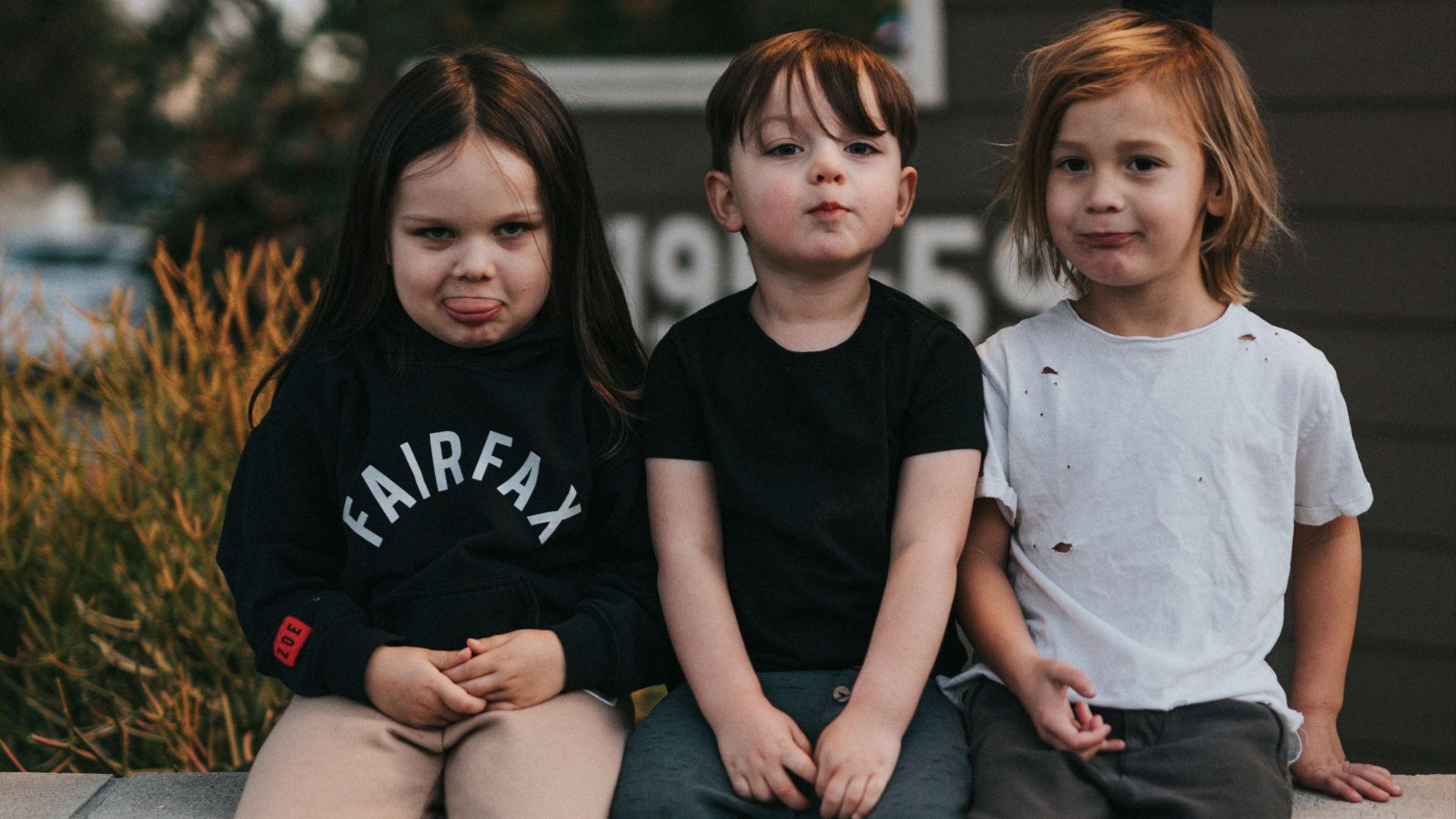 3 boys sitting on concrete stairs