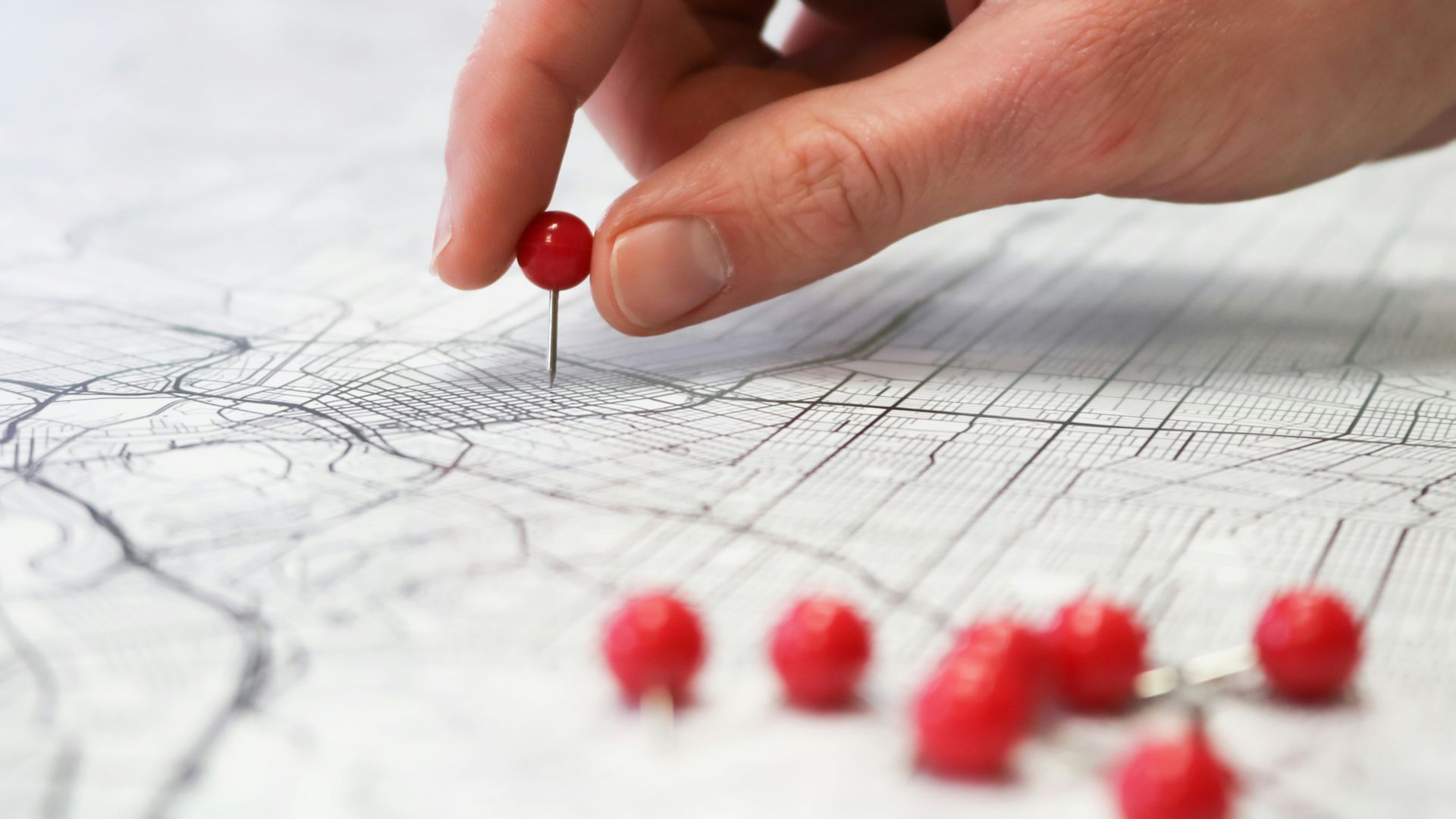 person holding red round medication pill