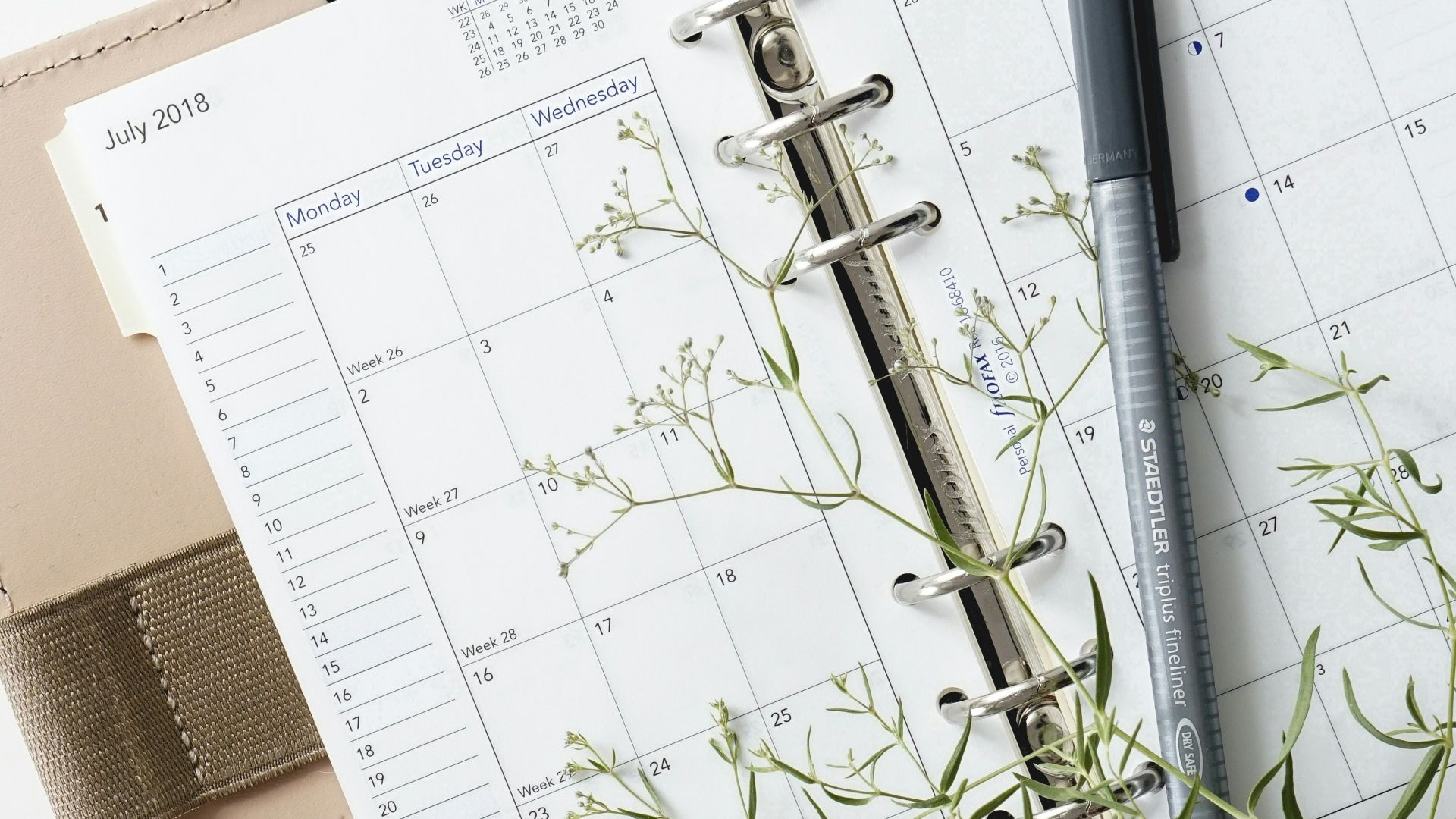 grey and black pen on calendar book