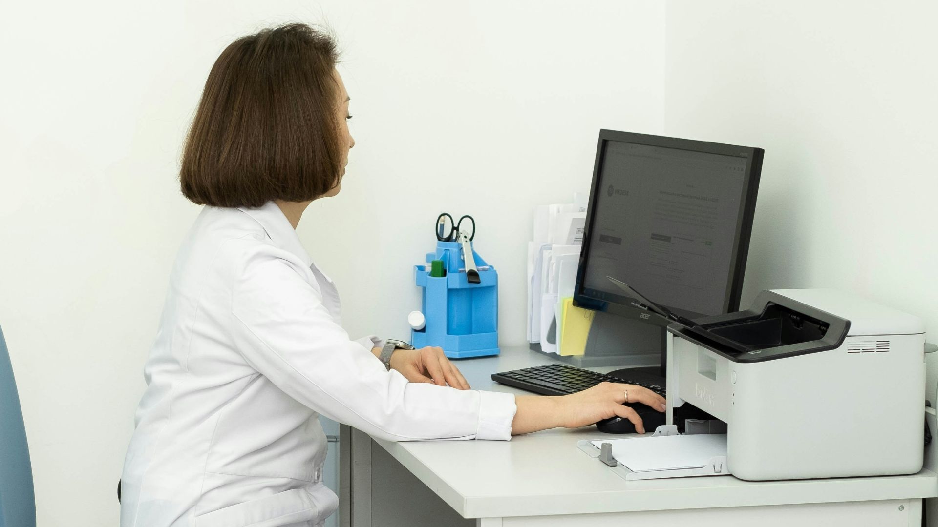 a woman sitting at a desk using a computer