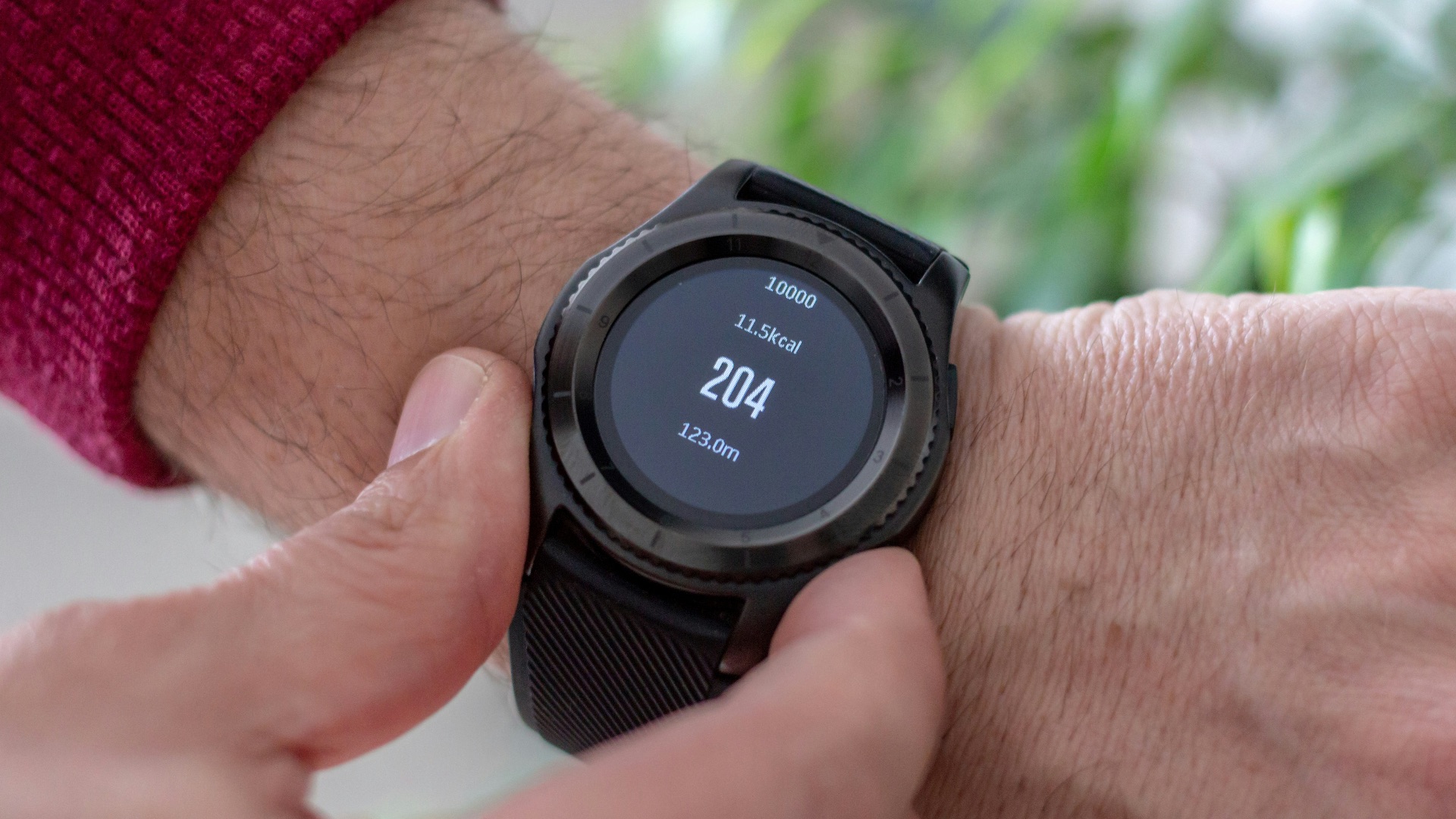 person wearing round black smartwatch