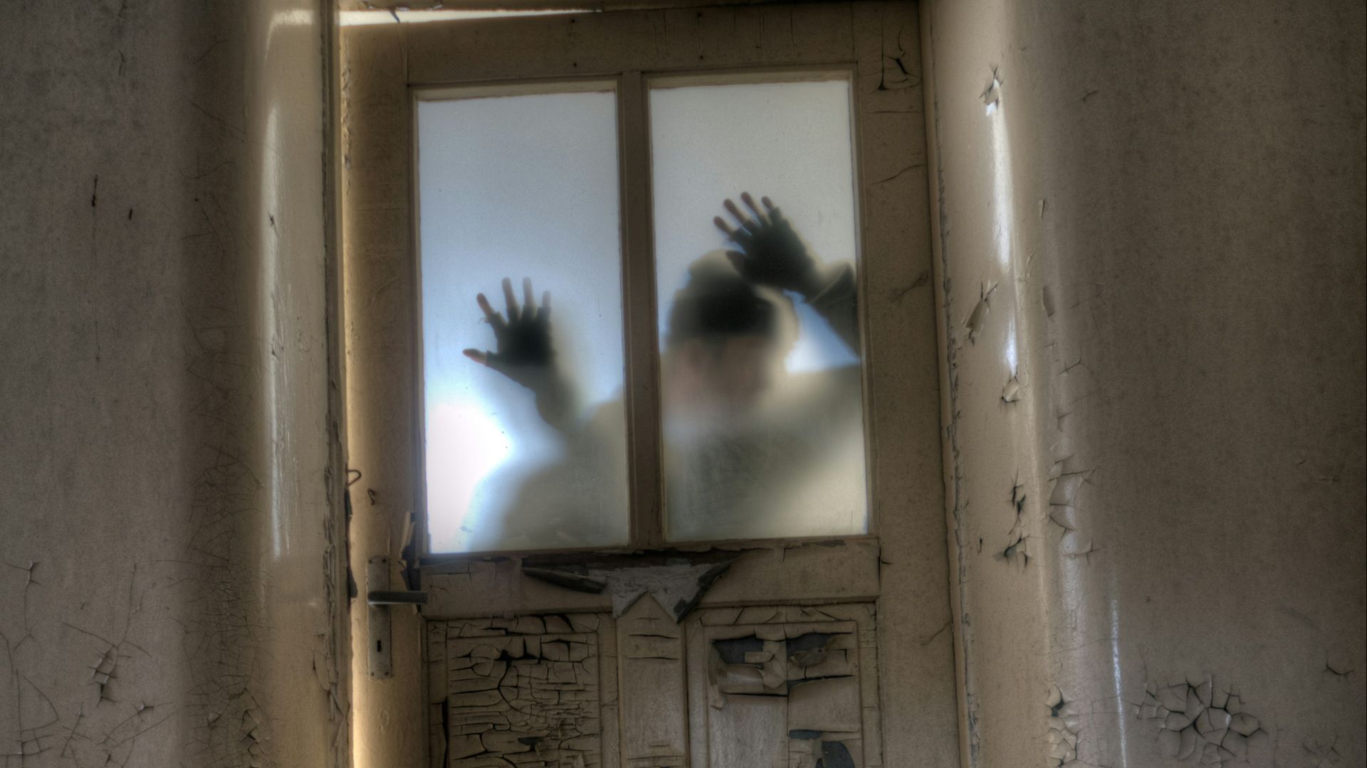 man leaning on frosted glass panel door