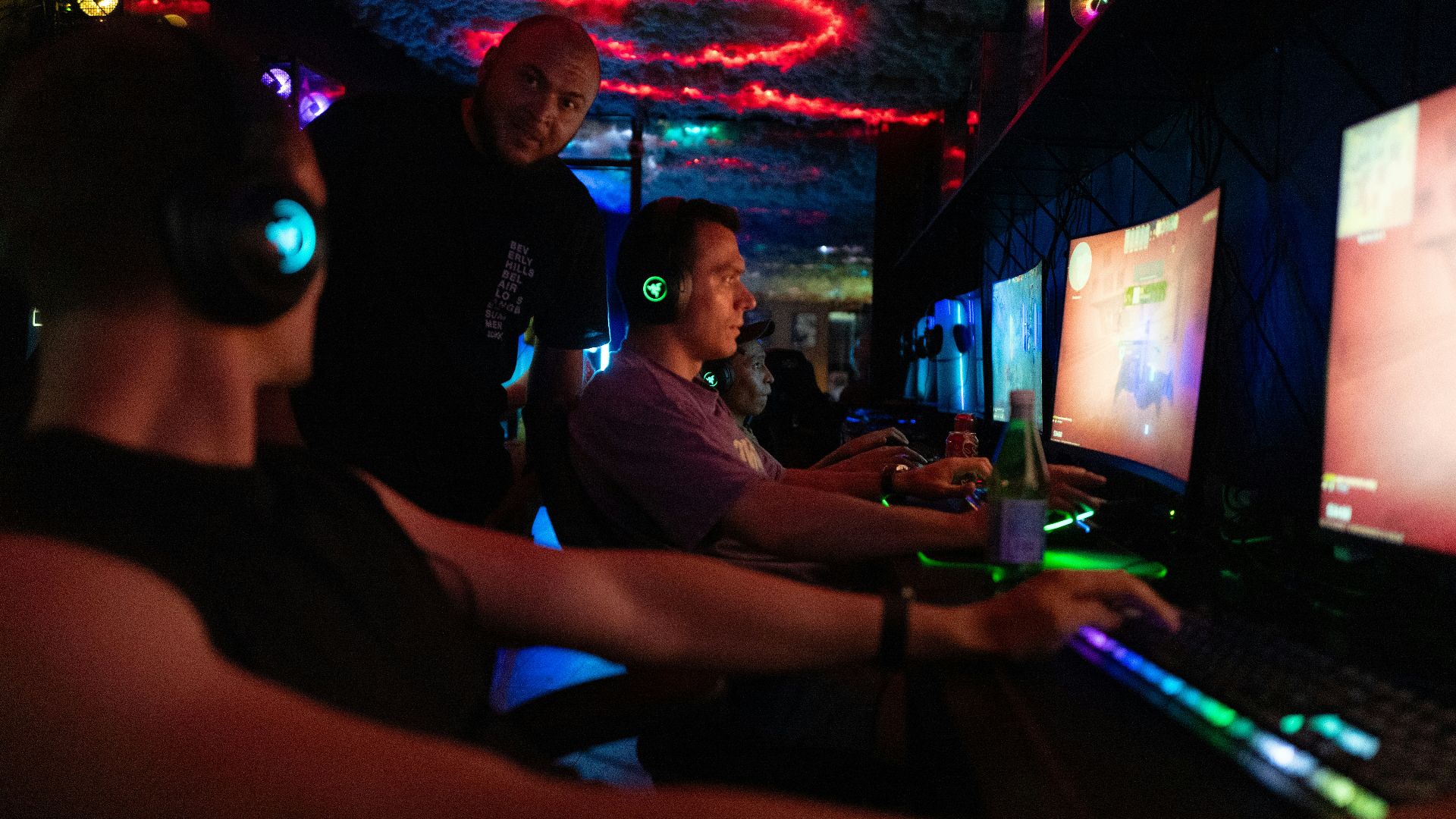 People playing video games in a dimly lit room.