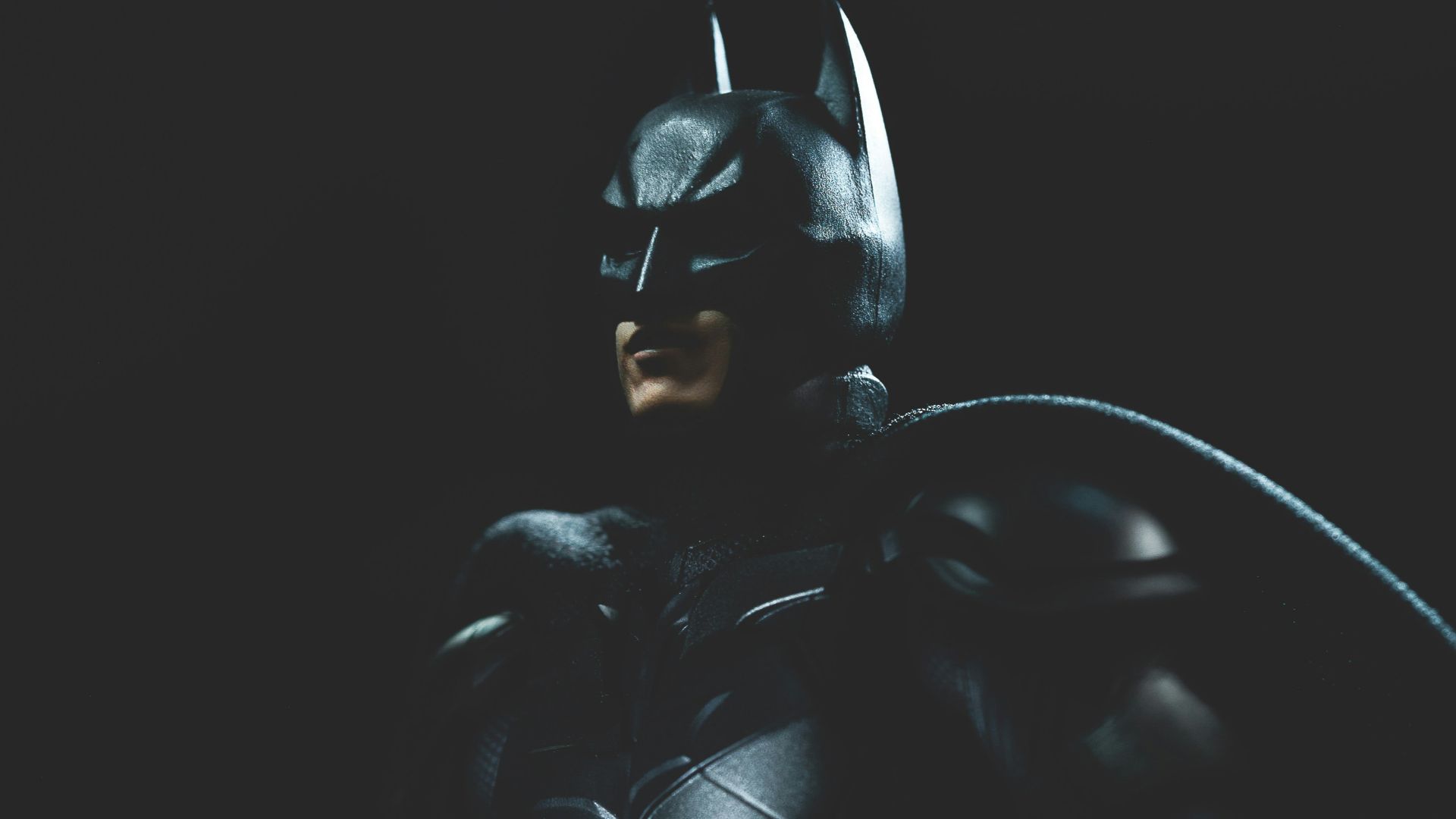 a man in a batman costume holding a bat