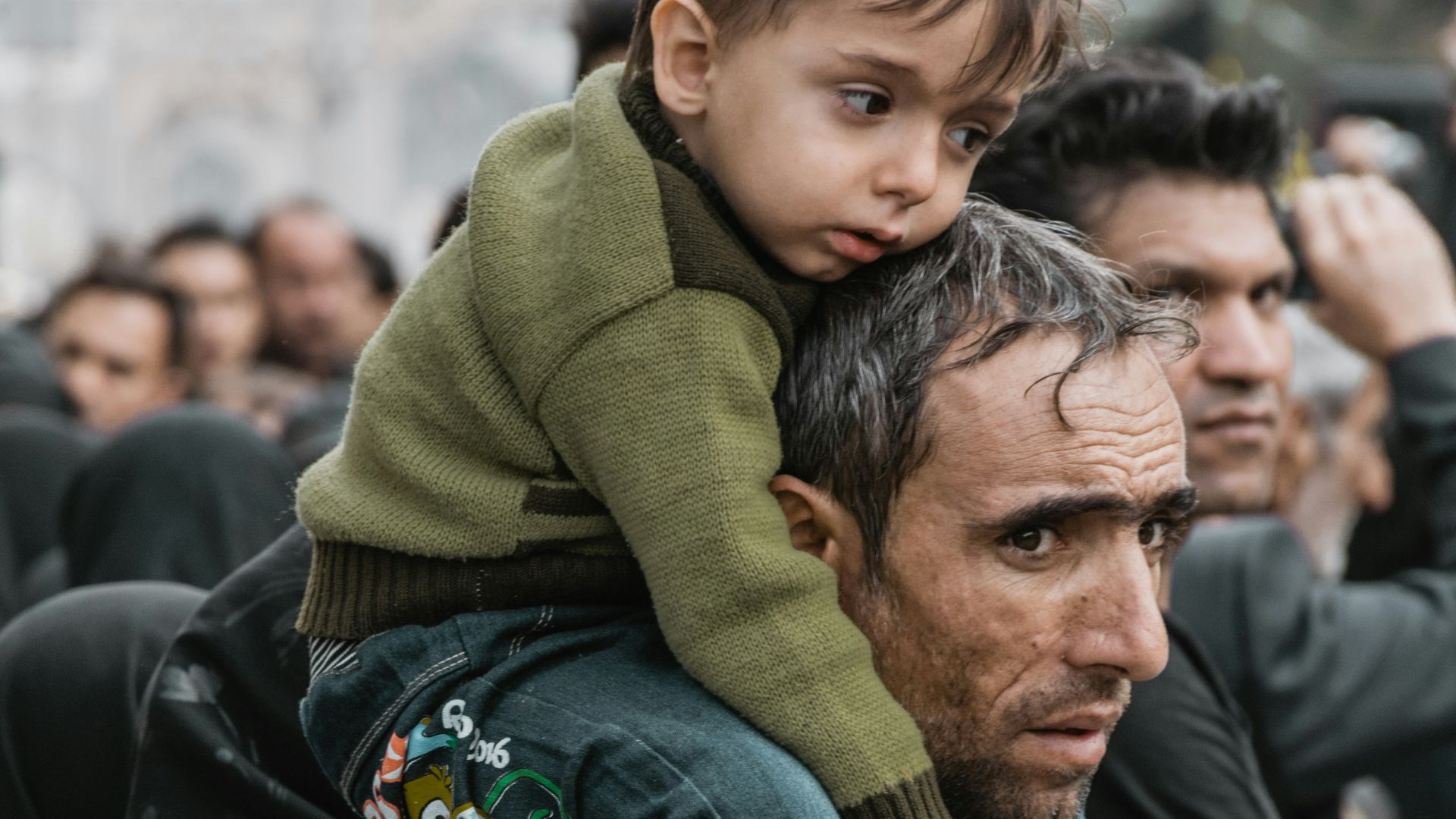 a man carrying a child on his shoulders