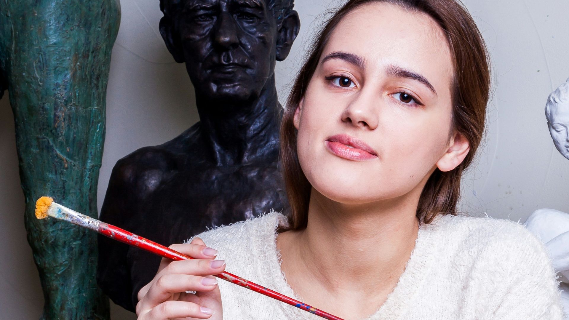 woman leaning on table and holding paint brush