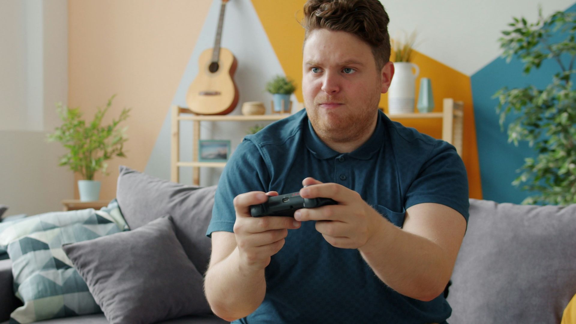 Man playing video games on a couch