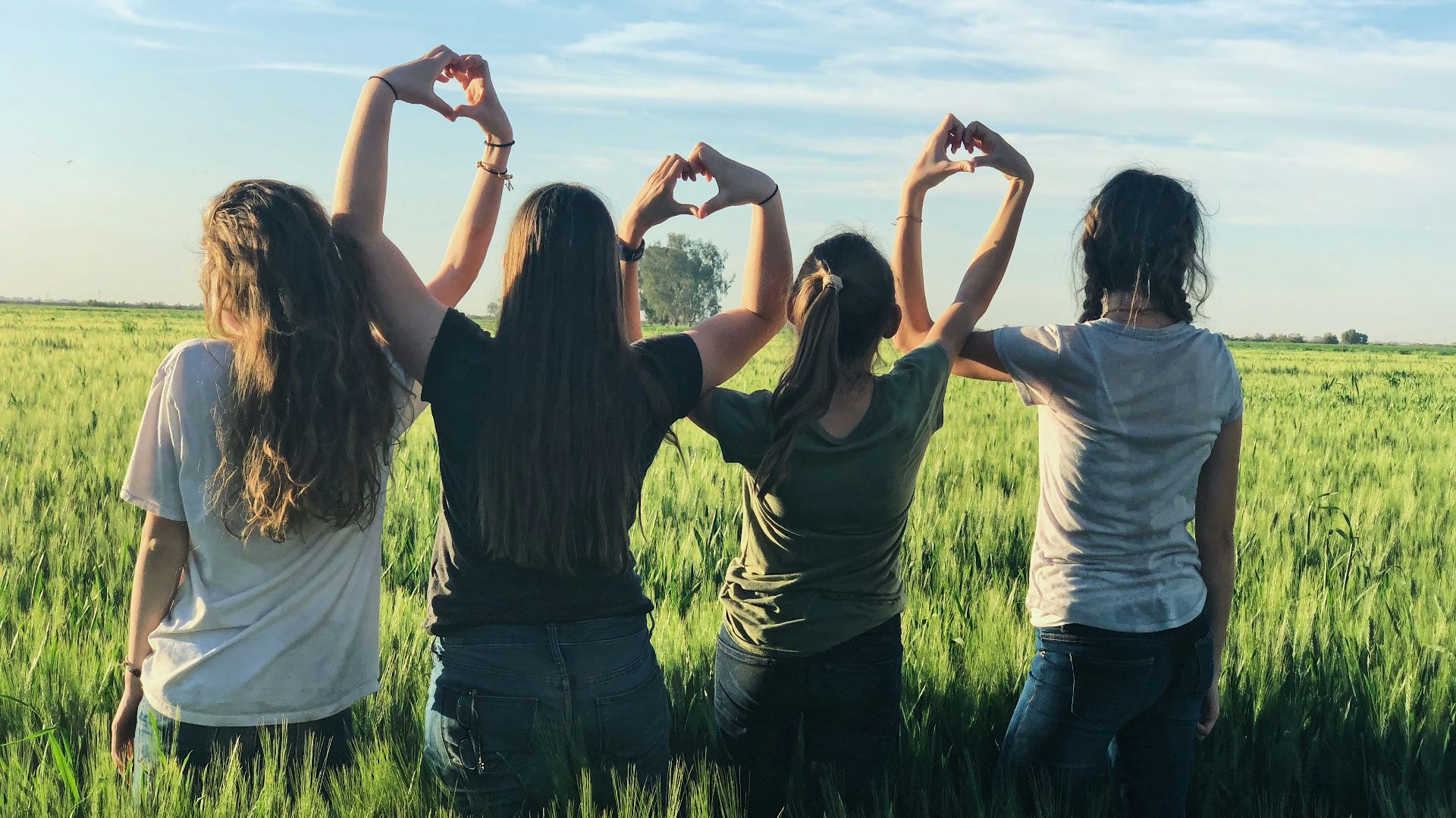 women forming heart gestures during daytime