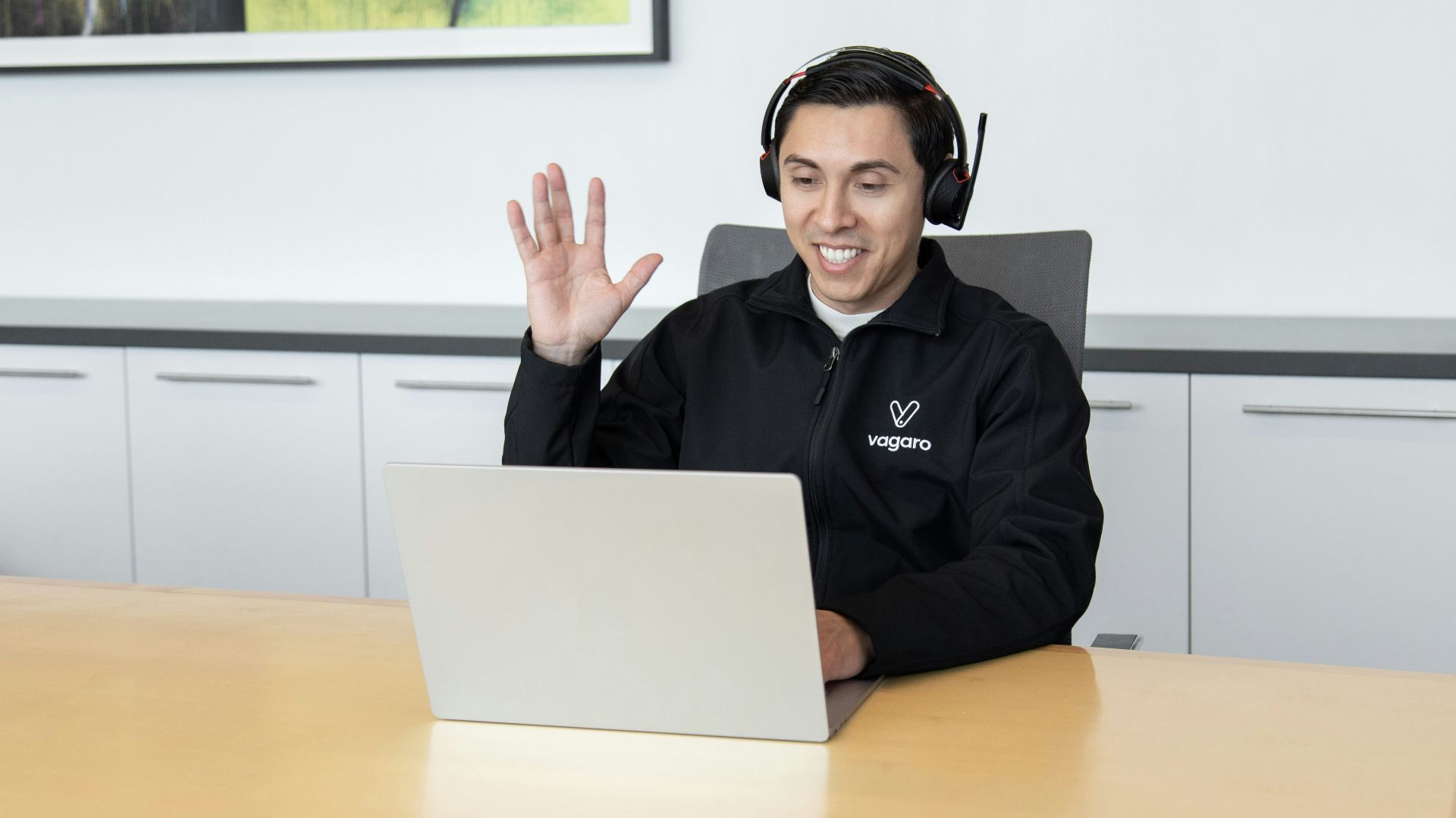 a man wearing headphones sitting in front of a laptop computer