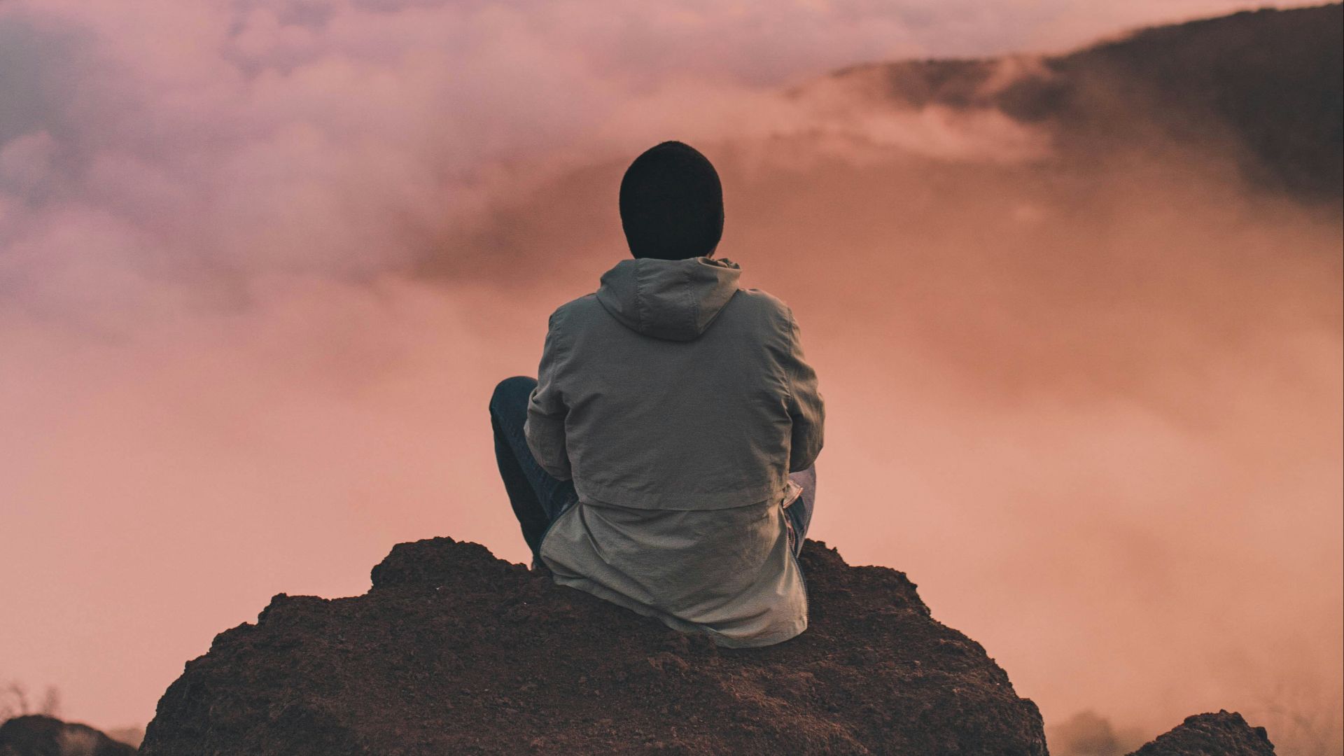 man sitting on cliff