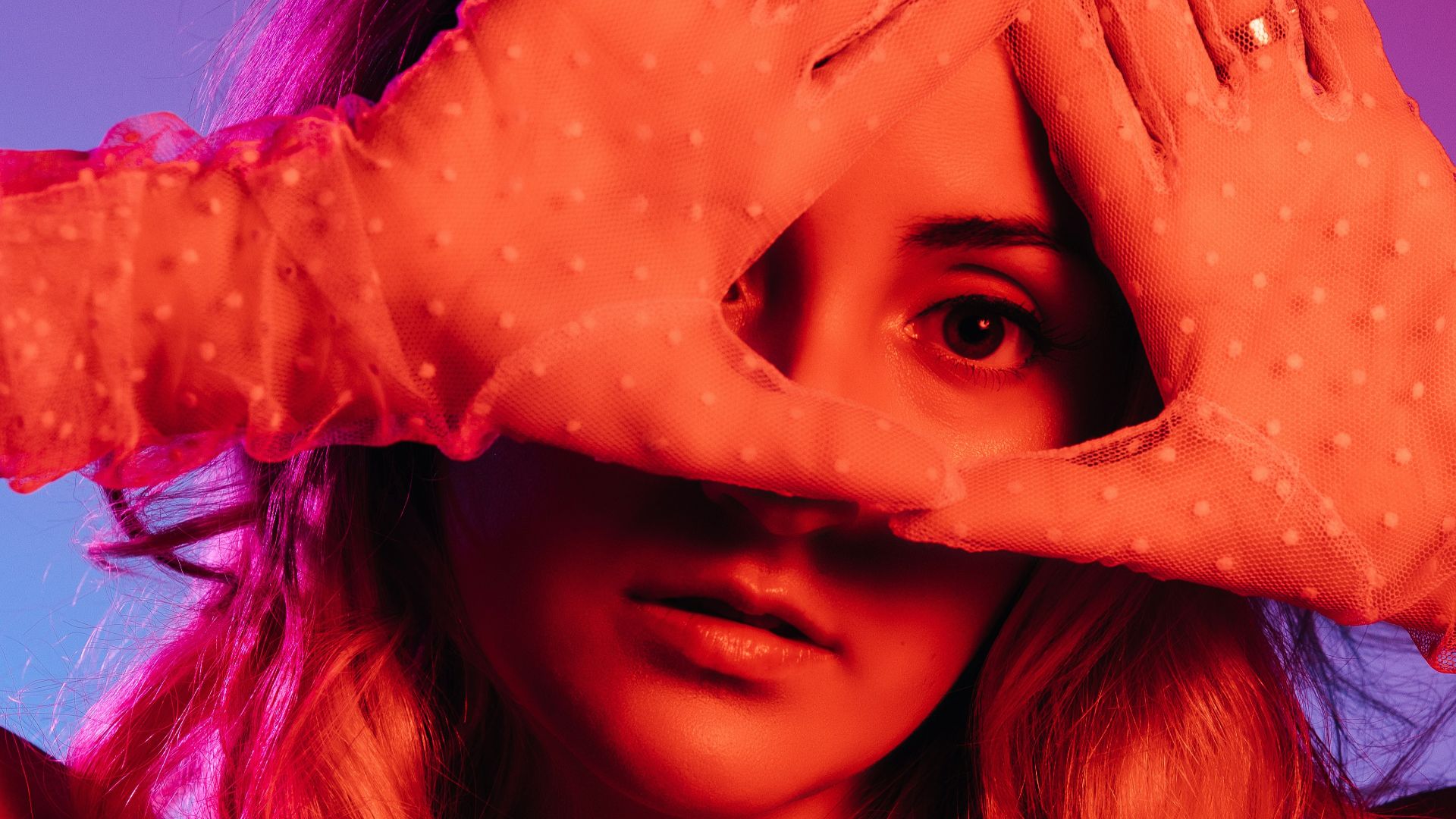 woman with brown hair covering her face with her hand