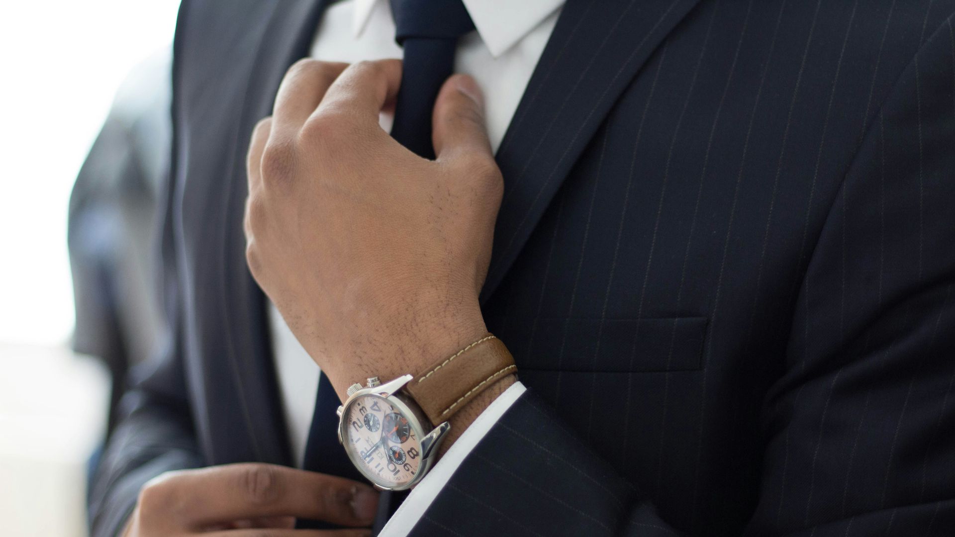 man wearing watch with black suit