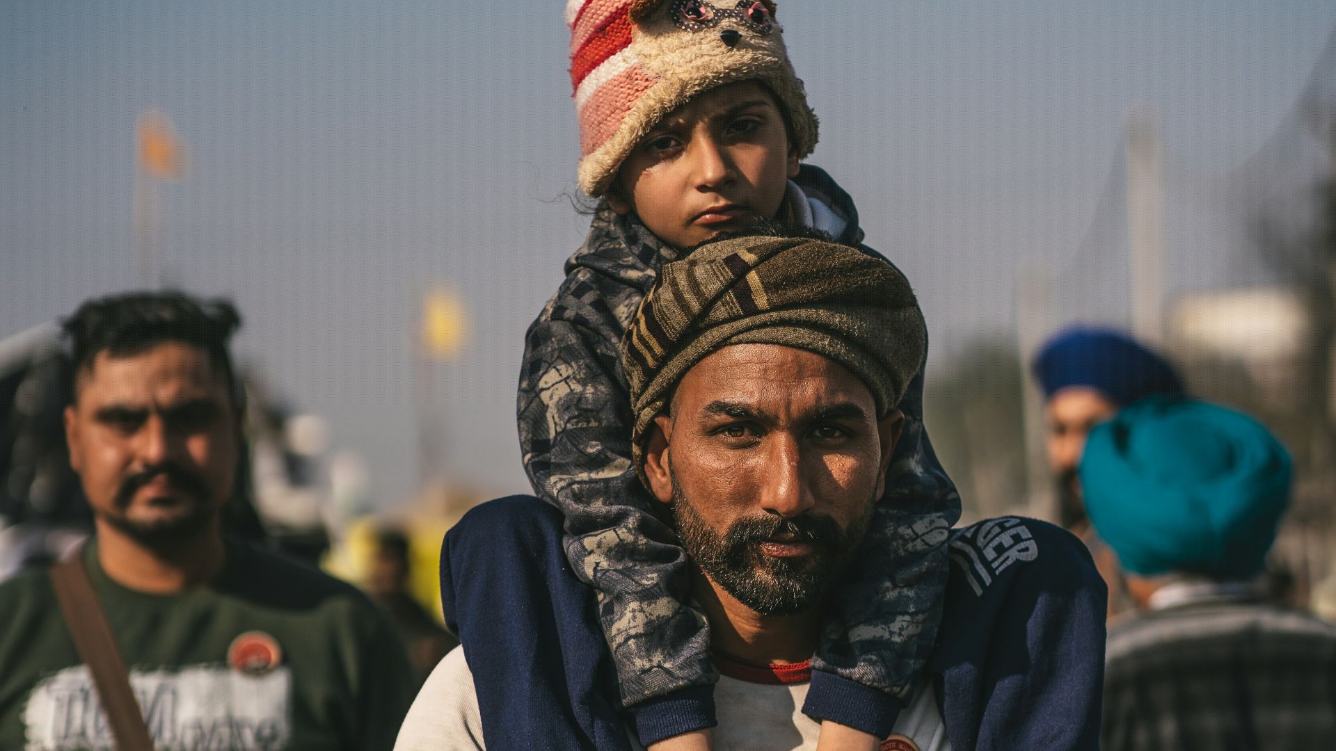 a man carrying a child on his shoulders