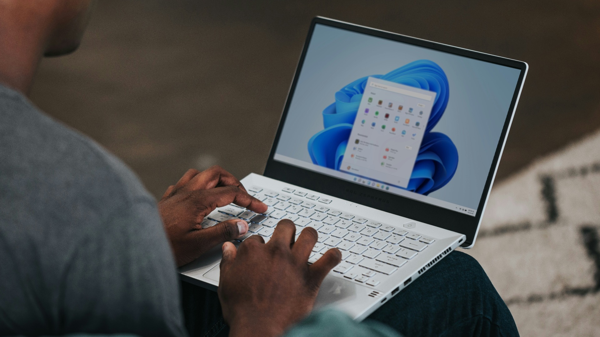 man in gray long sleeve shirt using Windows 11 computer