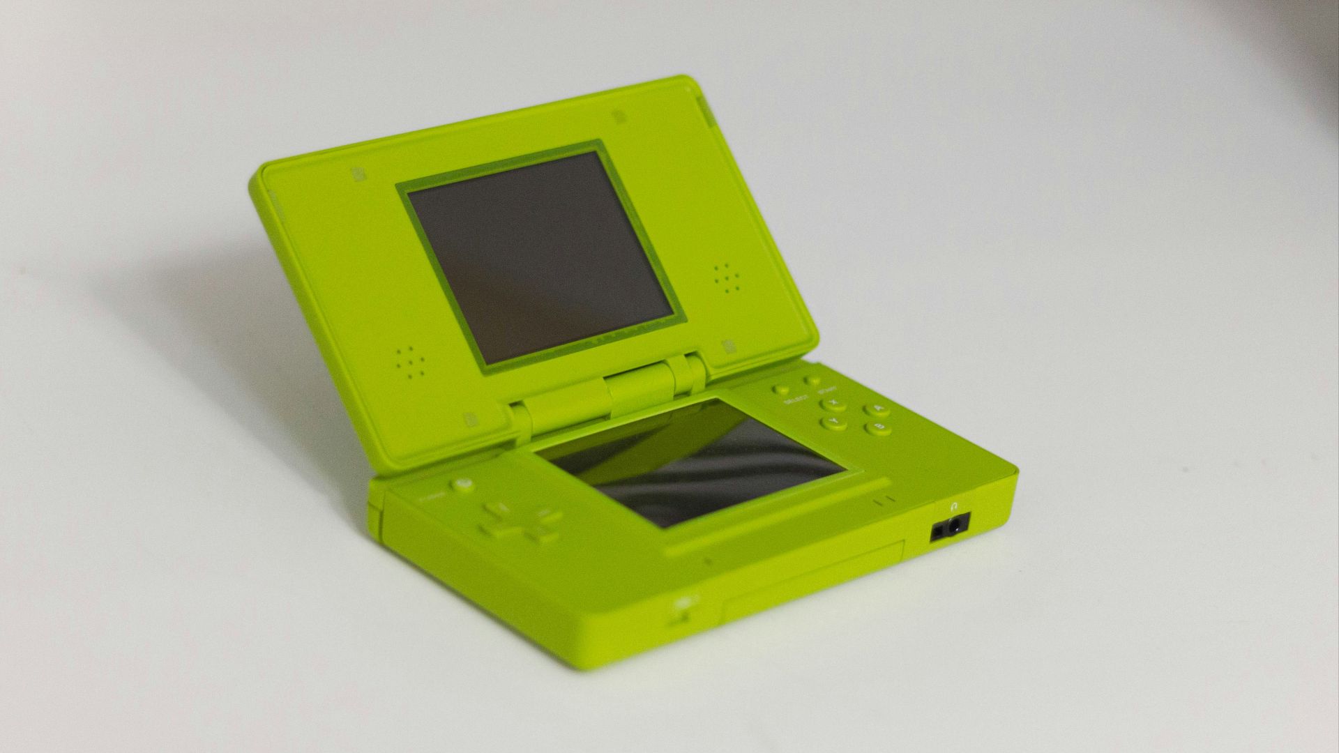 A lime green nintendo ds is displayed open.
