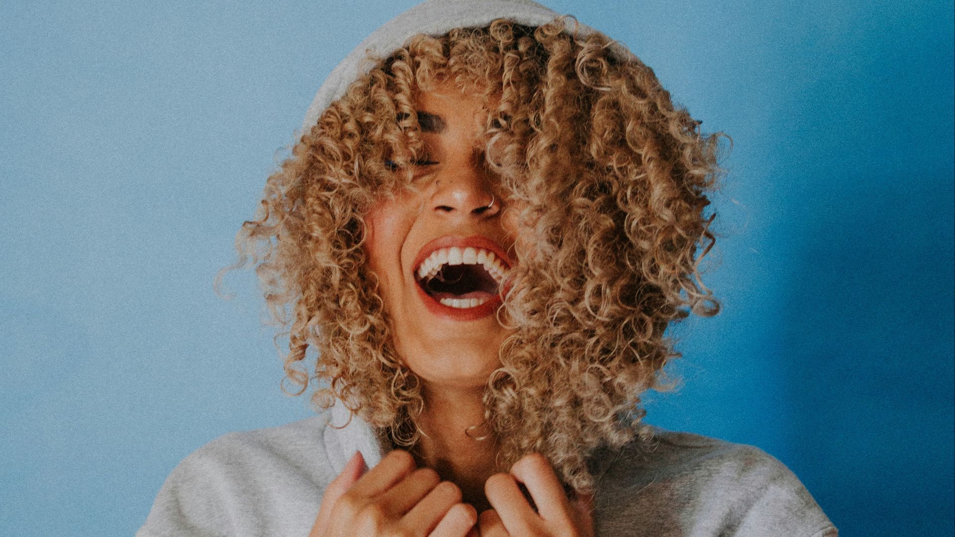 smiling woman wearing gray hoodie