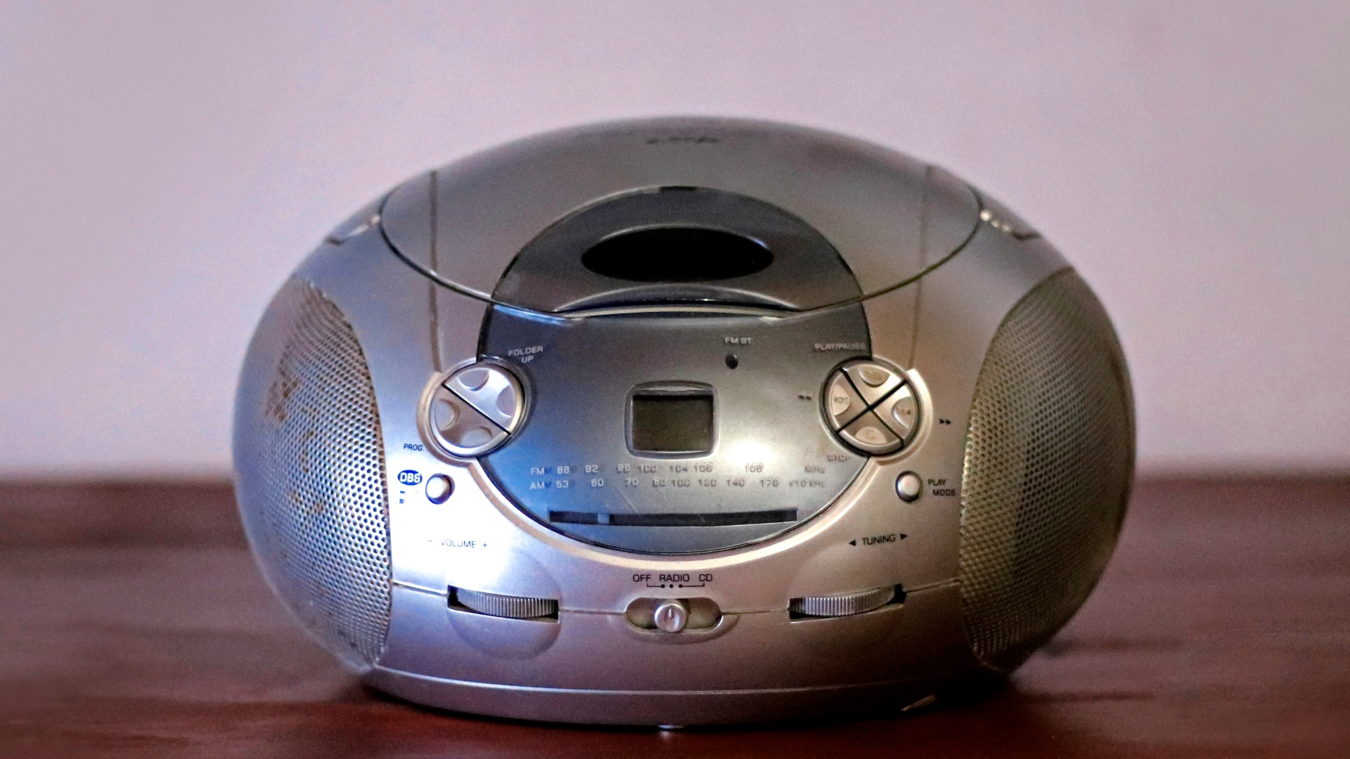 A silver alarm clock sitting on top of a wooden table