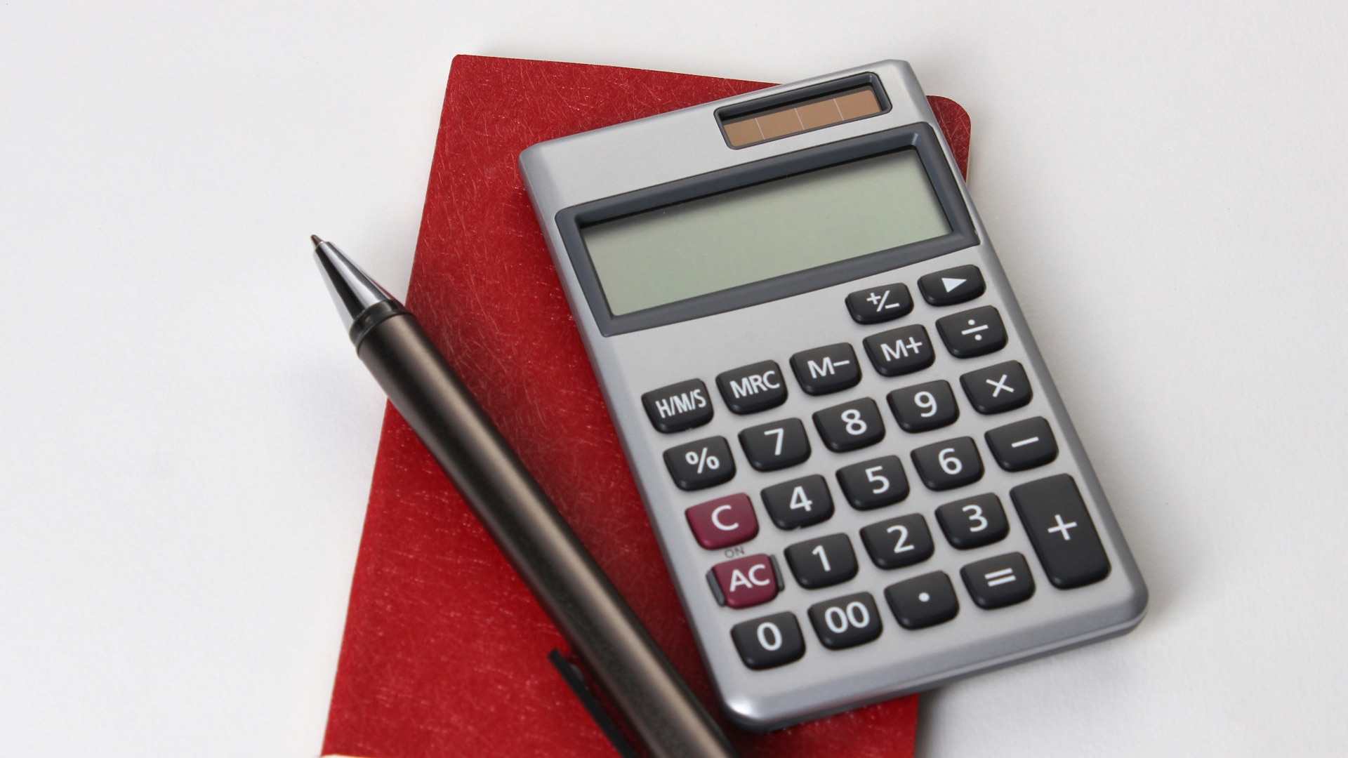black and silver calculator beside black pen