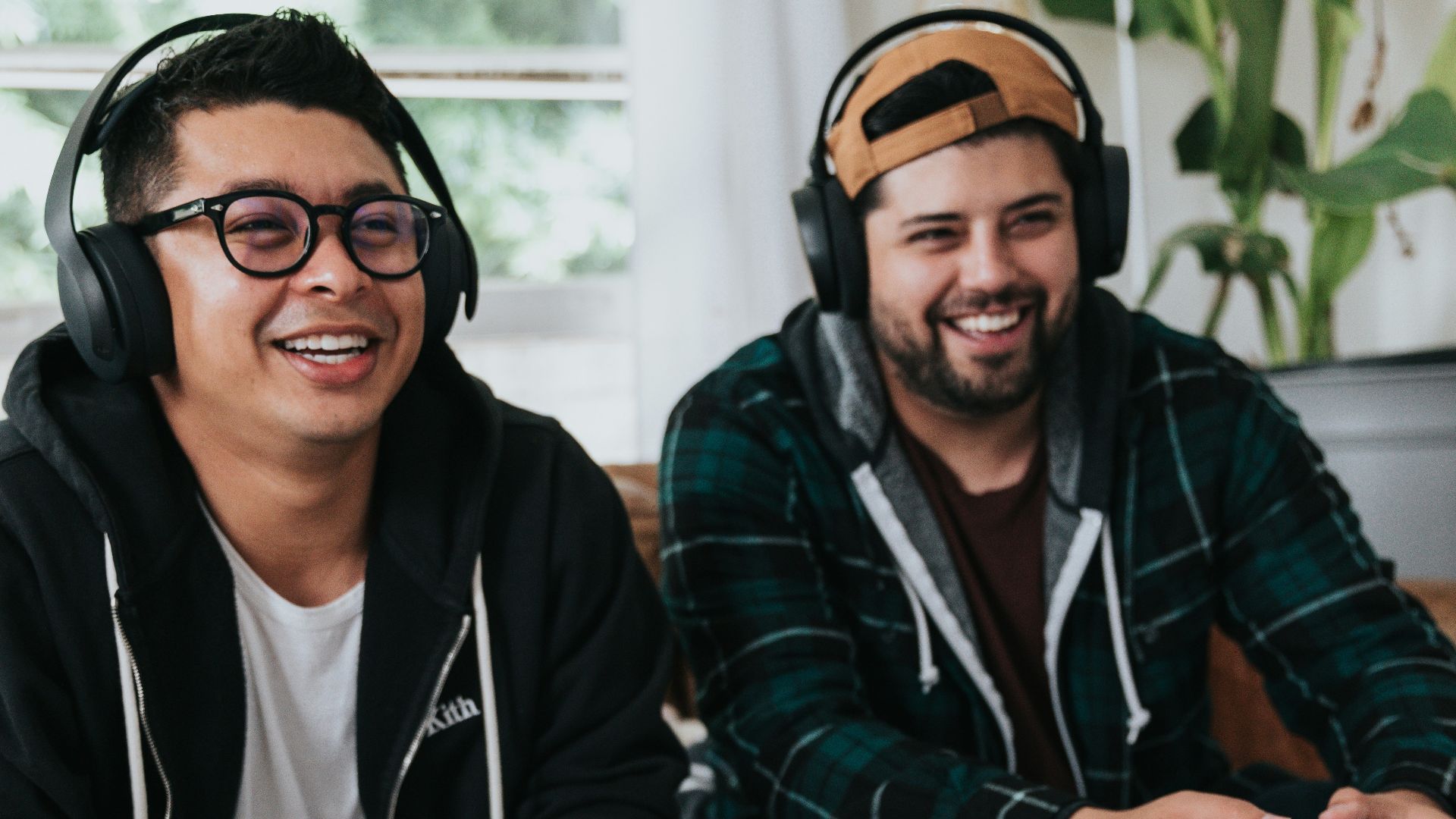 a couple of men sitting at a table with game controllers