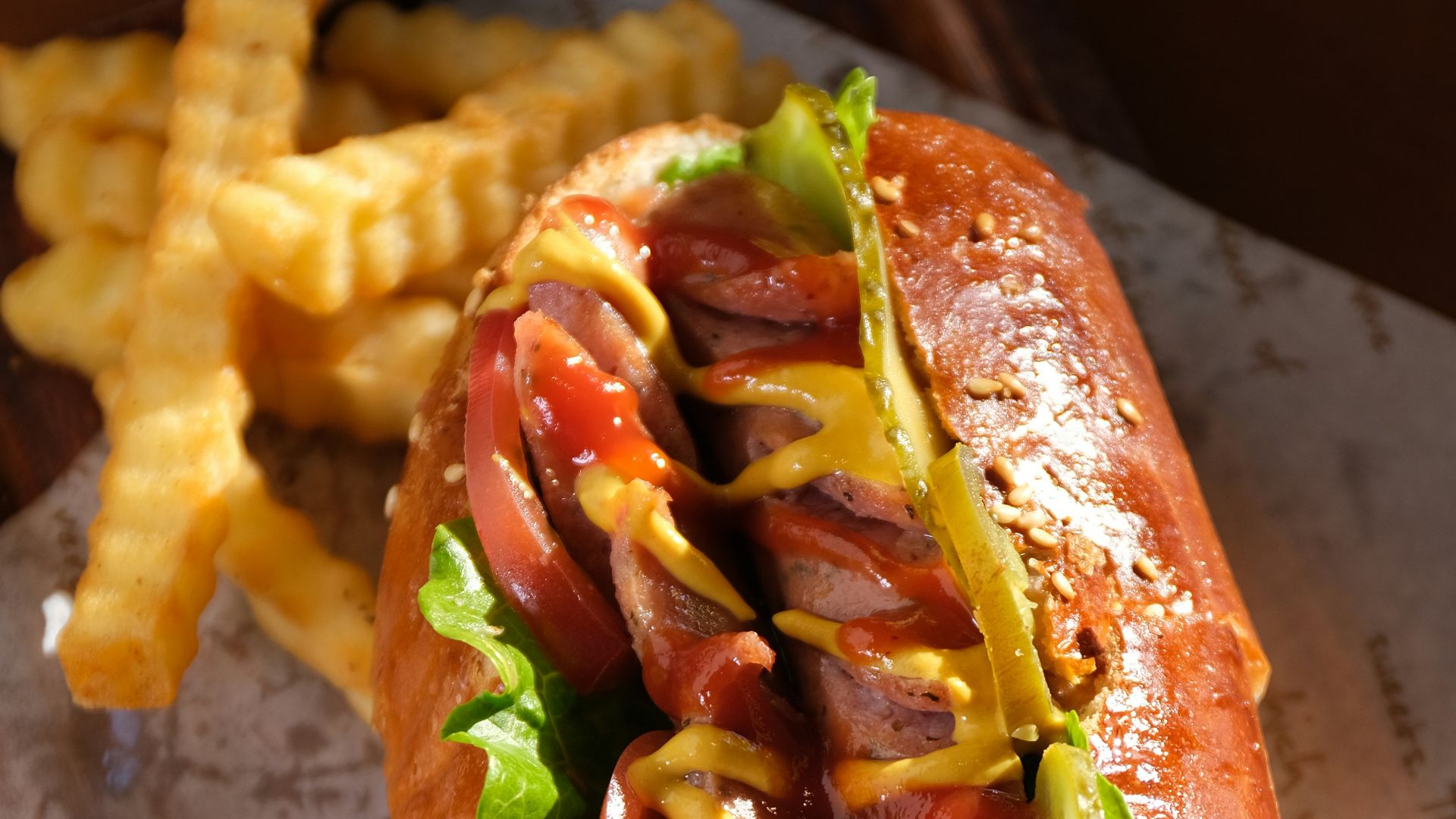 a hot dog on a bun with ketchup, mustard, and relish