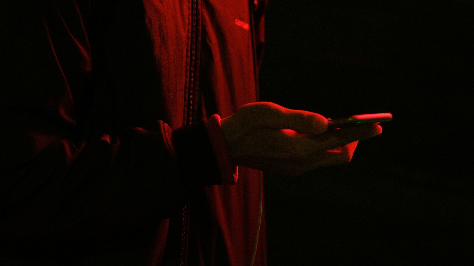 Person in a baseball cap looking at a phone.