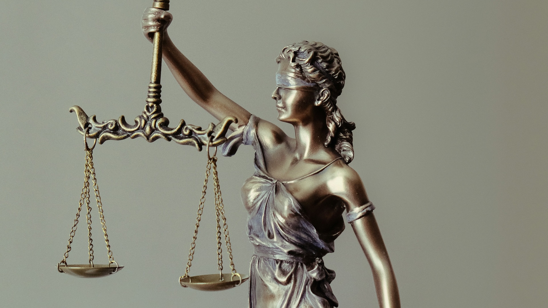 woman in gold dress holding sword figurine