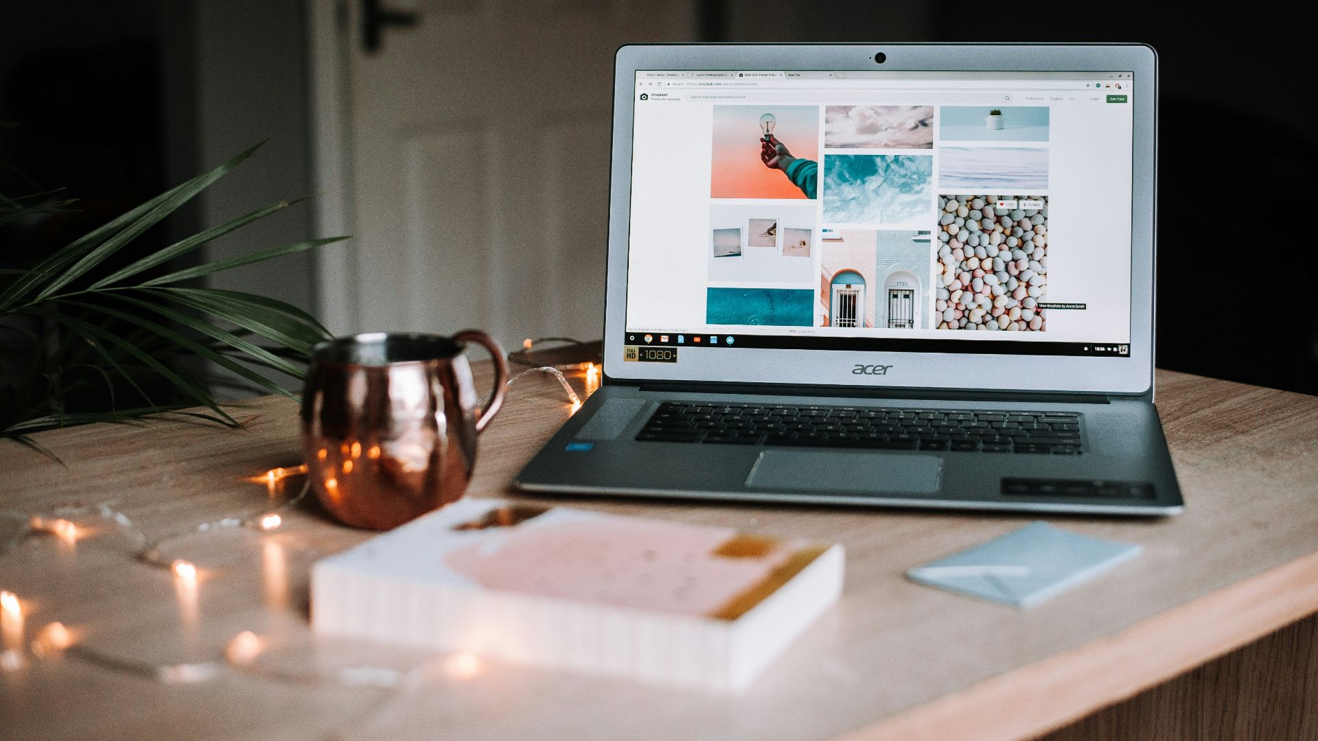 turned on Acer laptop on table near cup