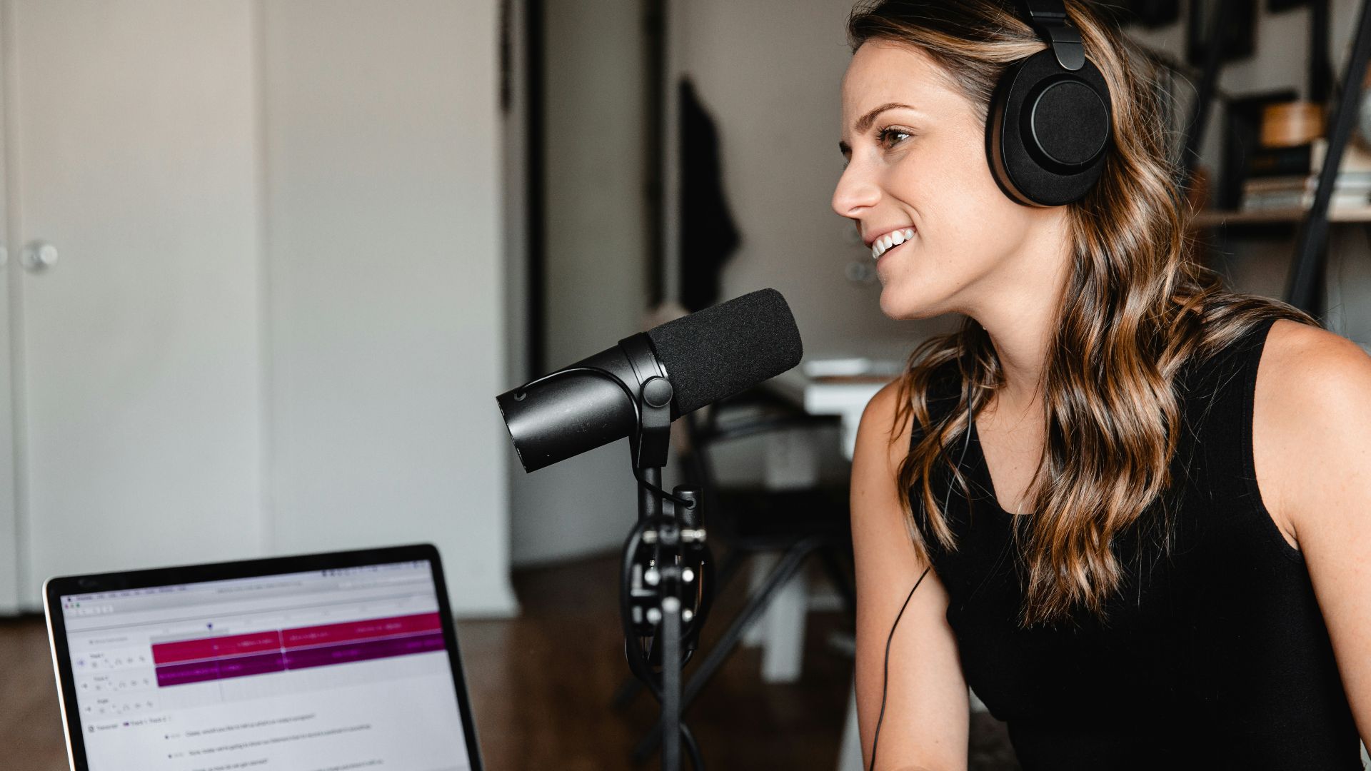 woman in black tank top sitting on chair in front of microphone