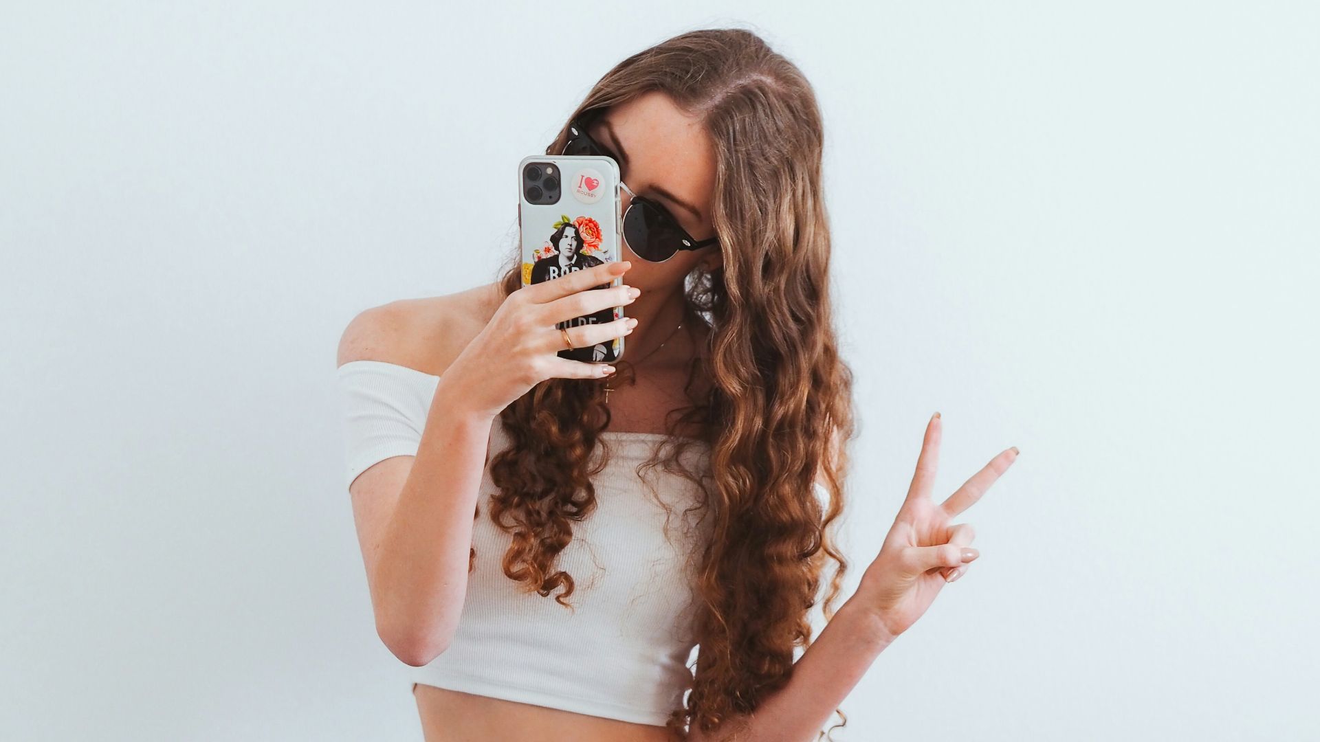 woman in pink tank top and blue denim jeans sitting on yellow chair