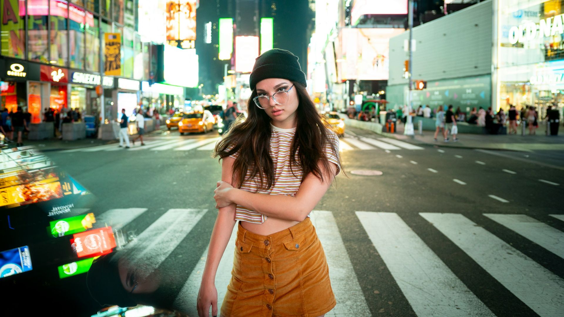woman wearing black beanie standing across highway