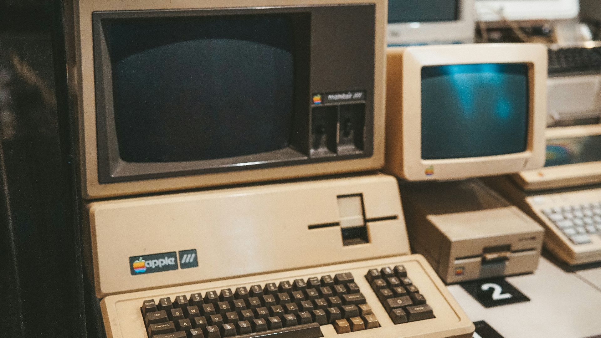 a row of old computers sitting on top of a desk