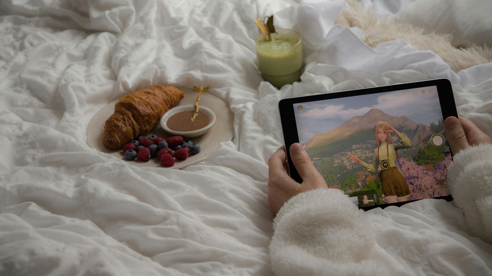 A person laying in bed holding a tablet