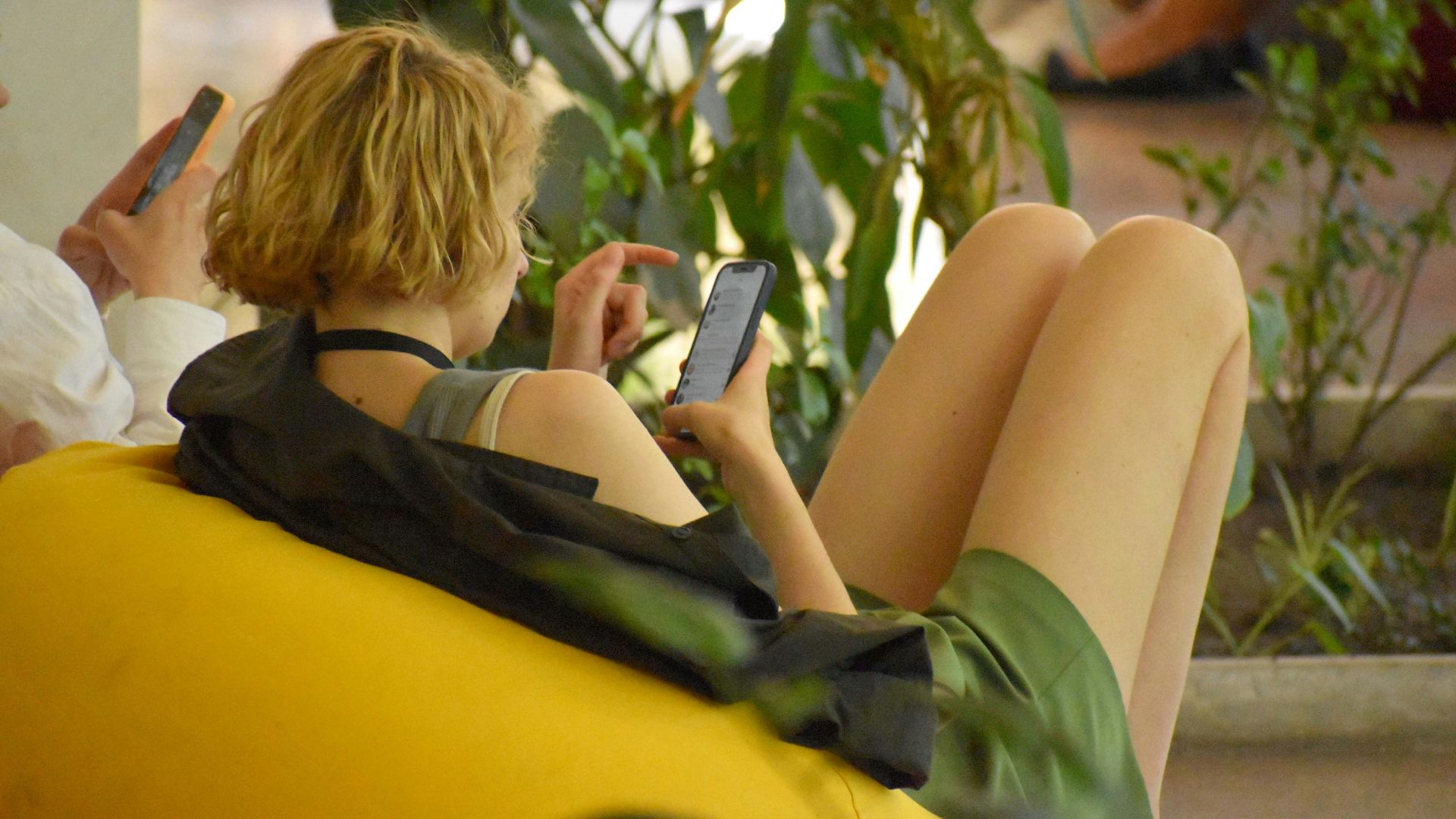 a woman sitting on a bench using her cell phone