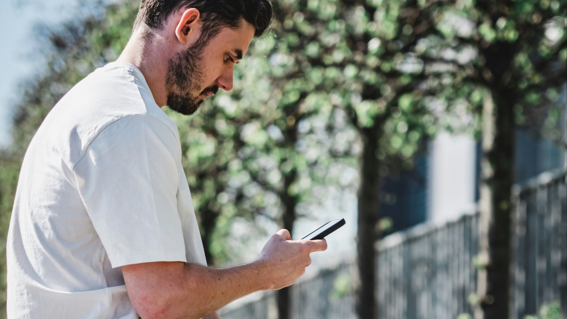 man in white dress shirt and black shorts sitting on brown concrete bench during daytime
