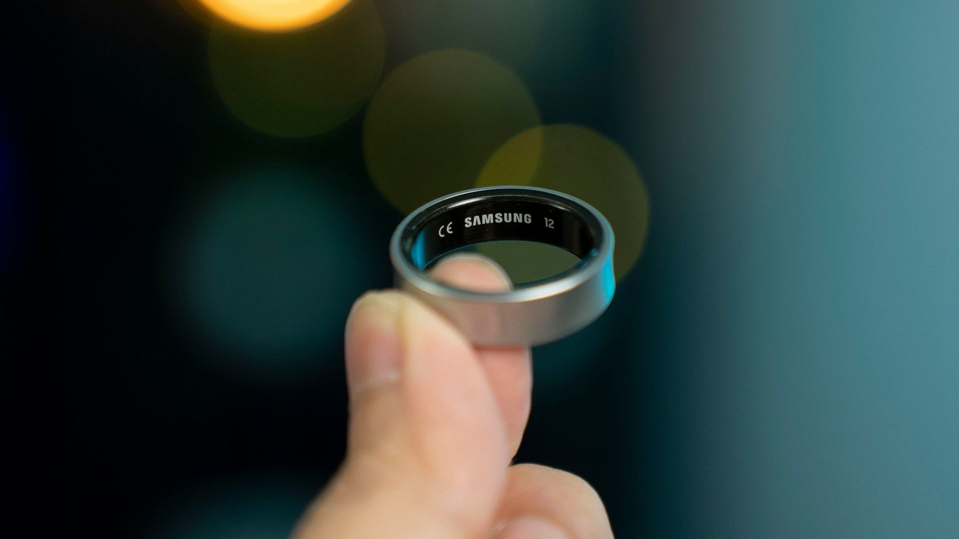 A hand is holding a smart ring.