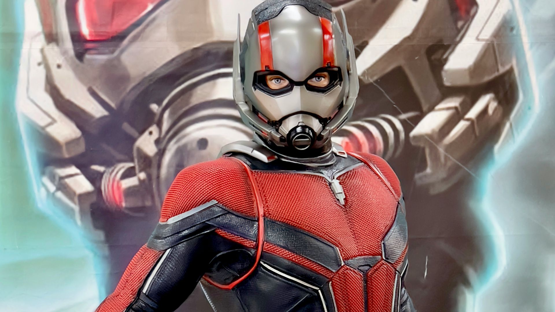 a man in a red and black suit standing next to a giant robot