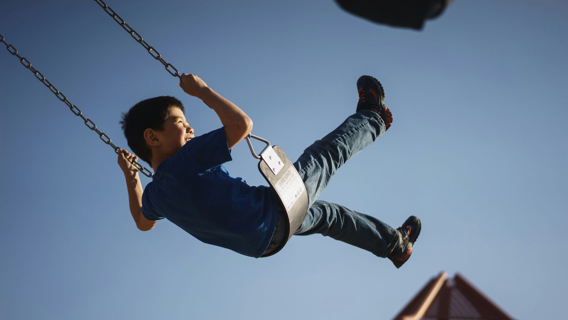 boy sitting on swing chair