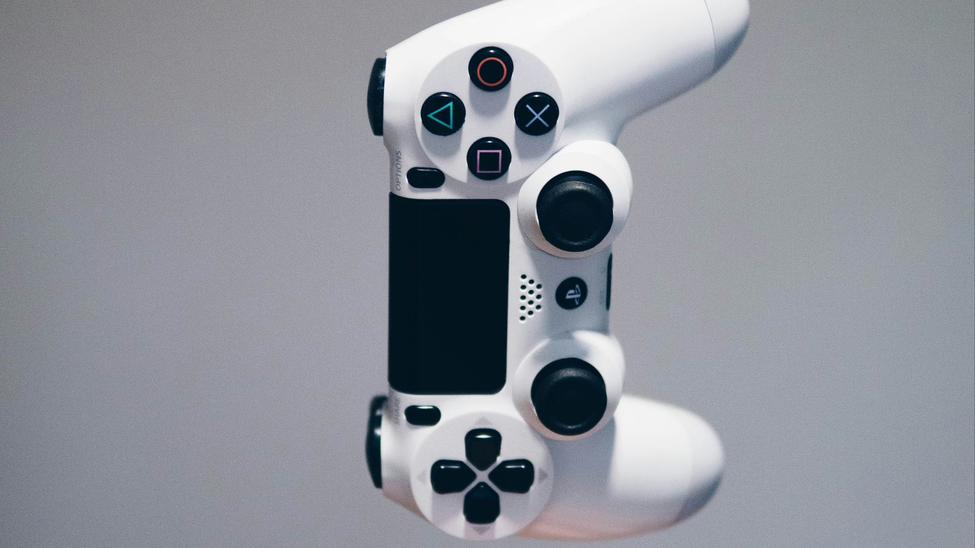 white Sony PS4 DualShock controller over person's palm