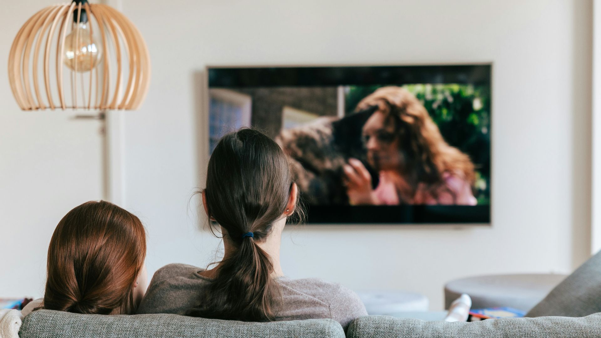 a couple of women sitting on top of a couch