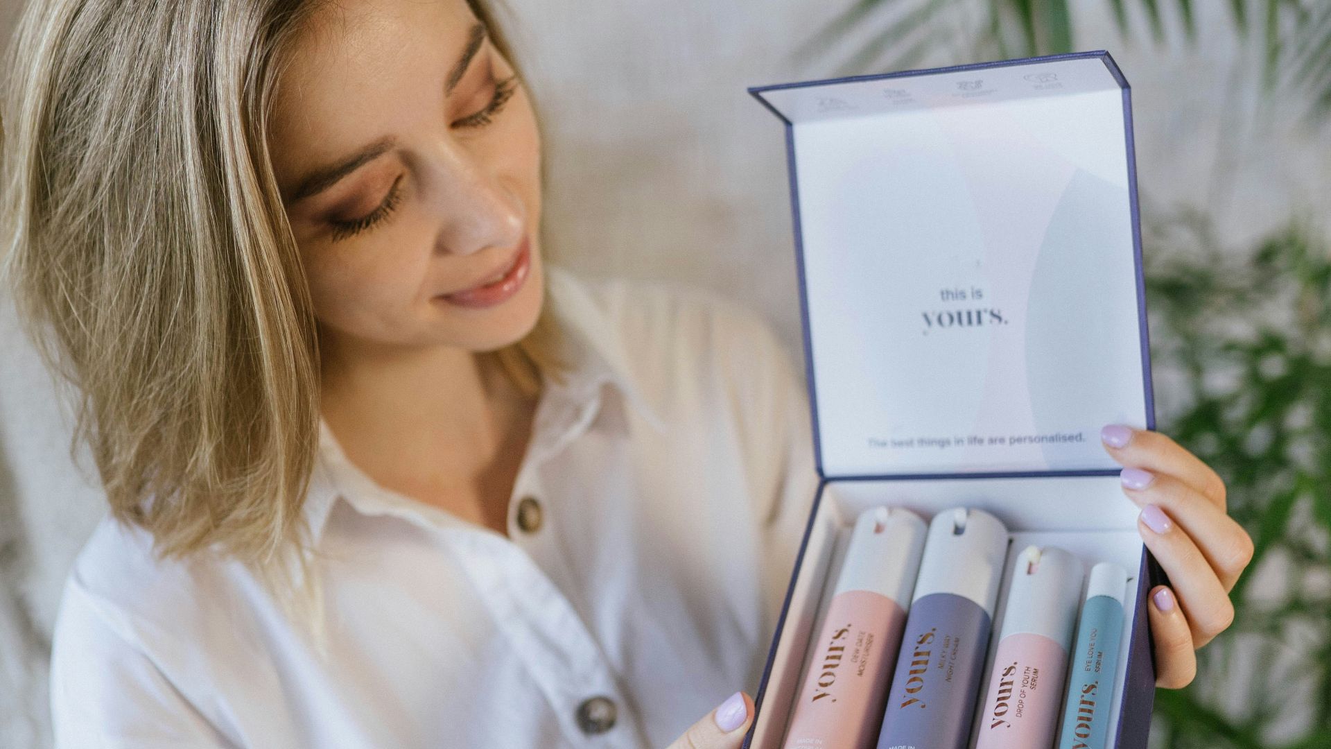 woman in white dress shirt holding white and blue box